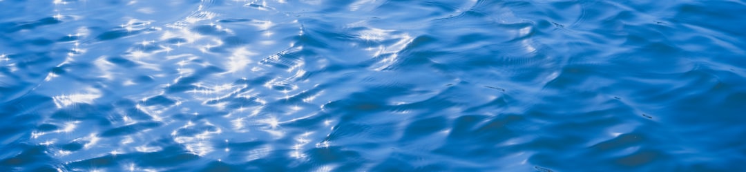 Sparkling blue water surface with sunlight reflections