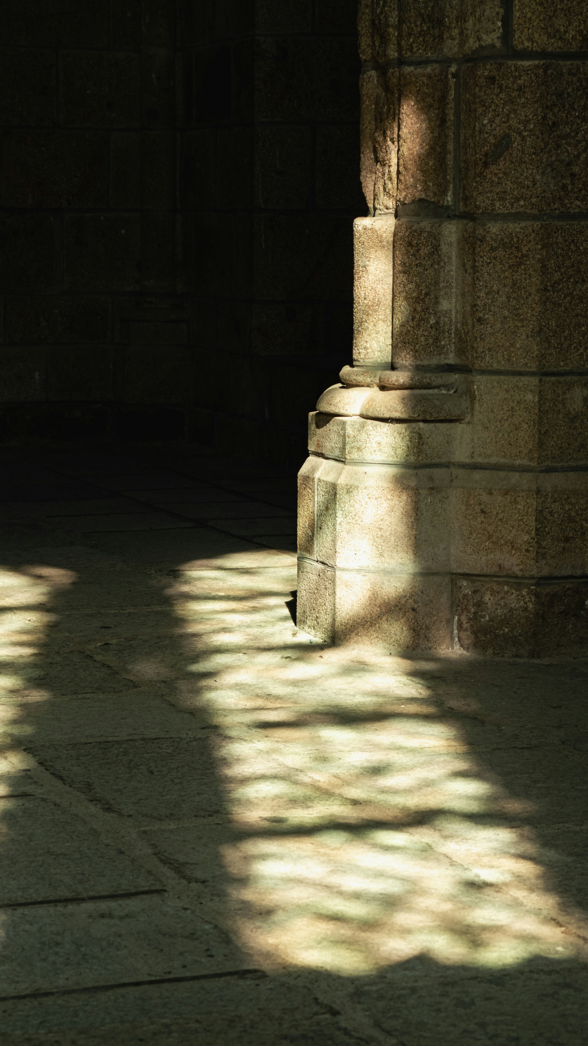 Sunlight streams through an archway onto stone floor.