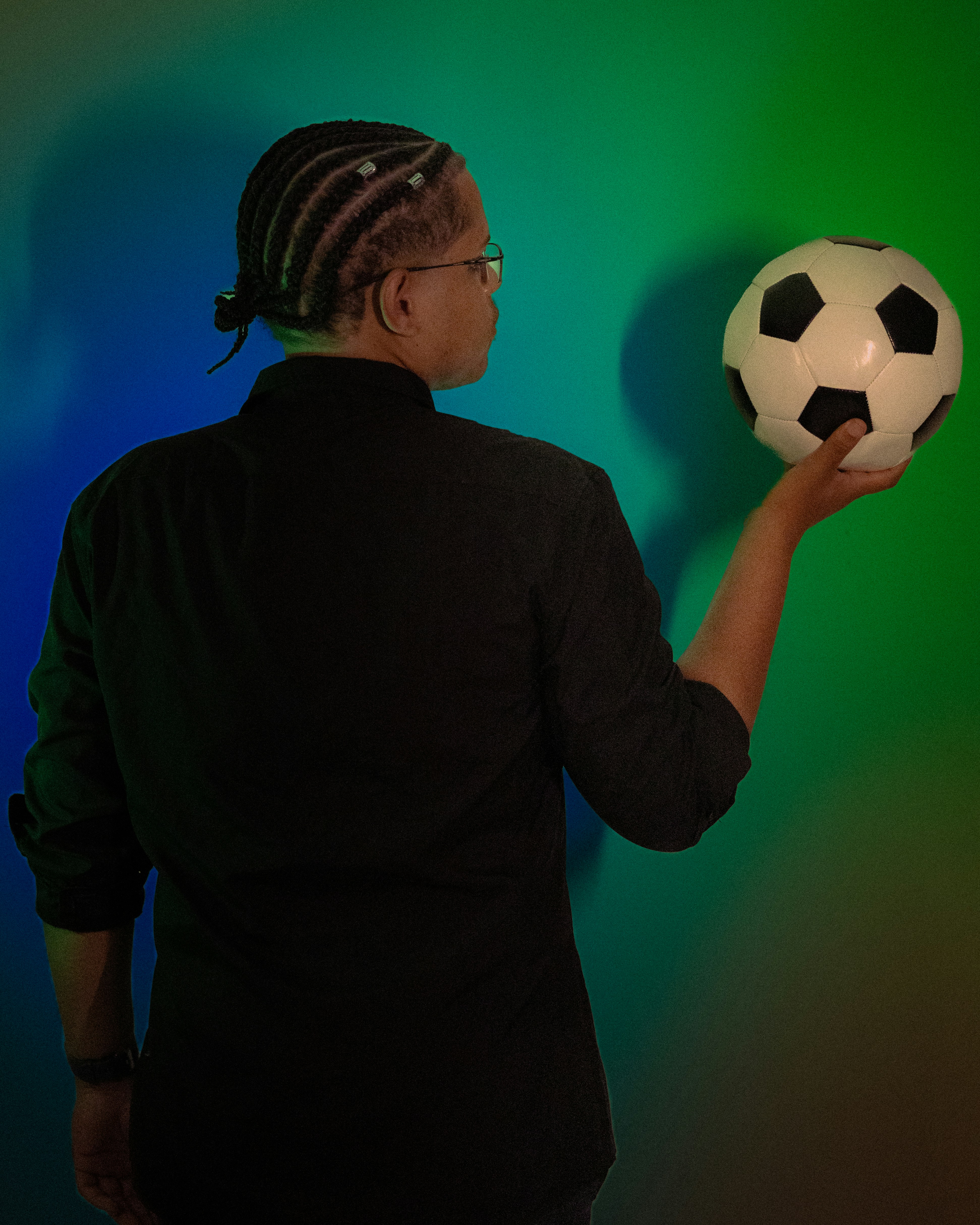 Person holding a soccer ball against colorful background