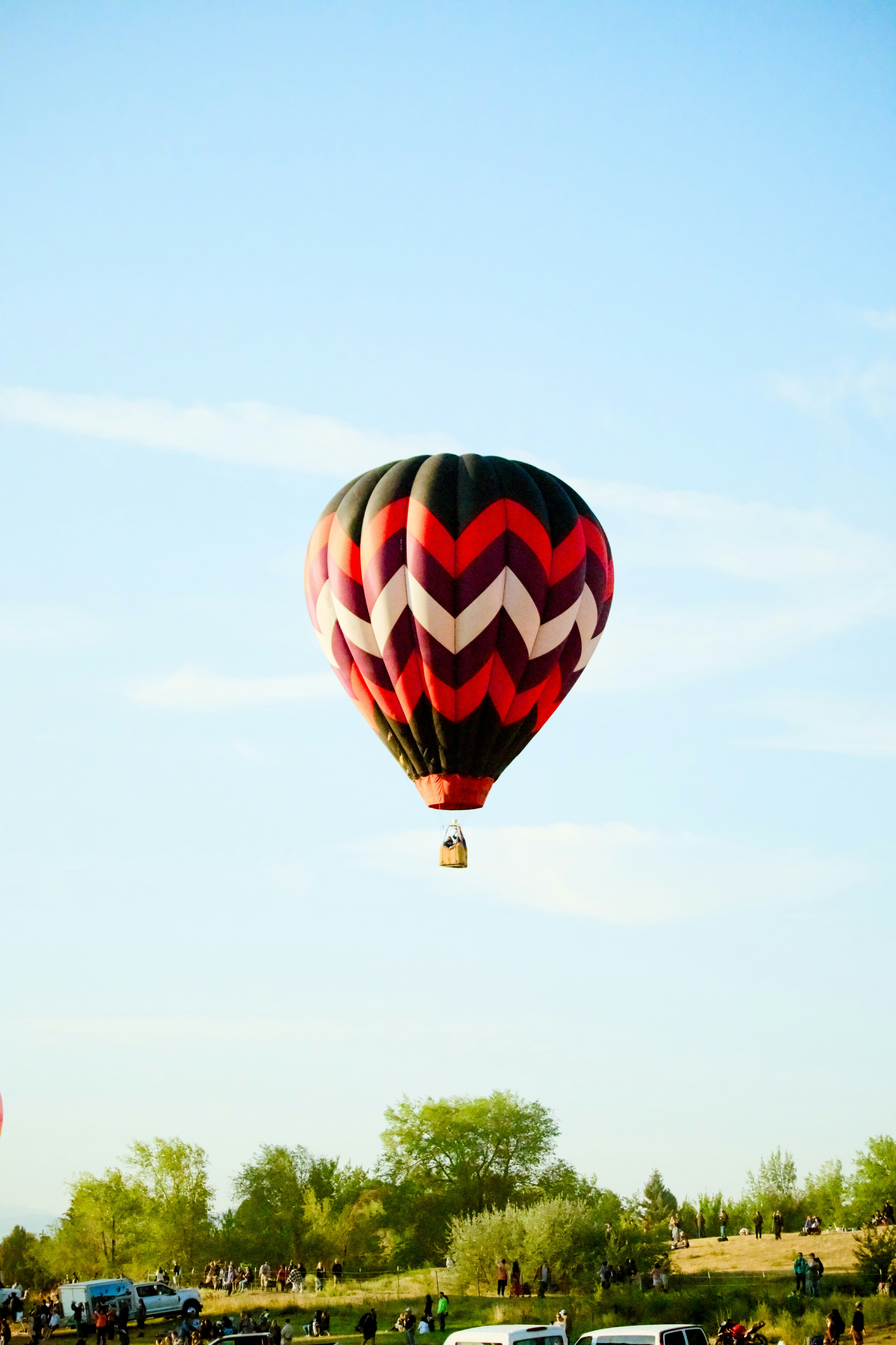 Un globo aerostático con un patrón de chevron vuela.
