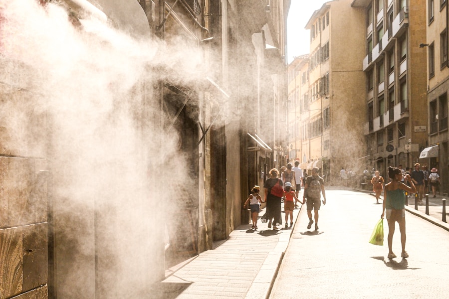 Passants sous les brumisateurs d'une rue de Florence pendant la canicule estivale 2025