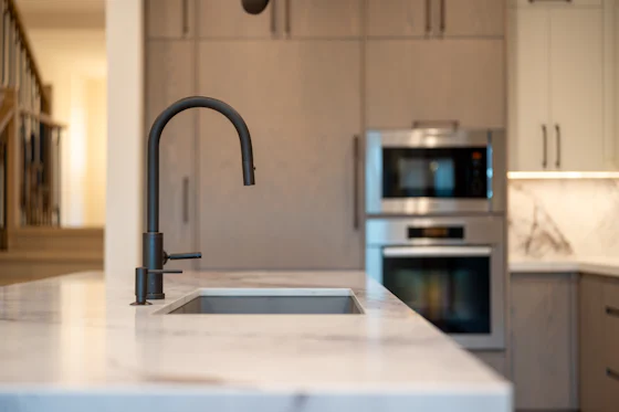 Modern kitchen sink built into cabinets near a Navien tankless system