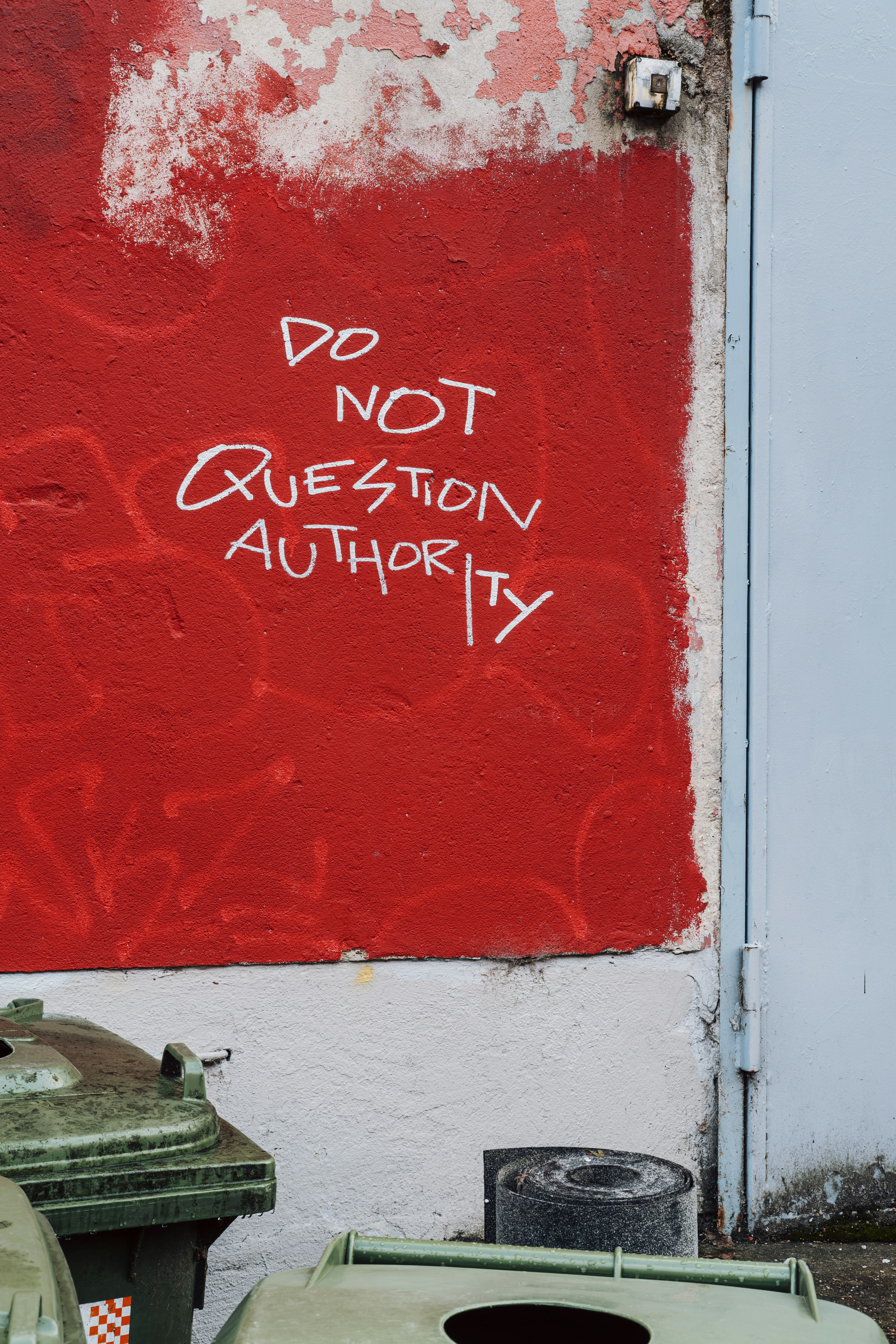 White text on red wall says do not question authority