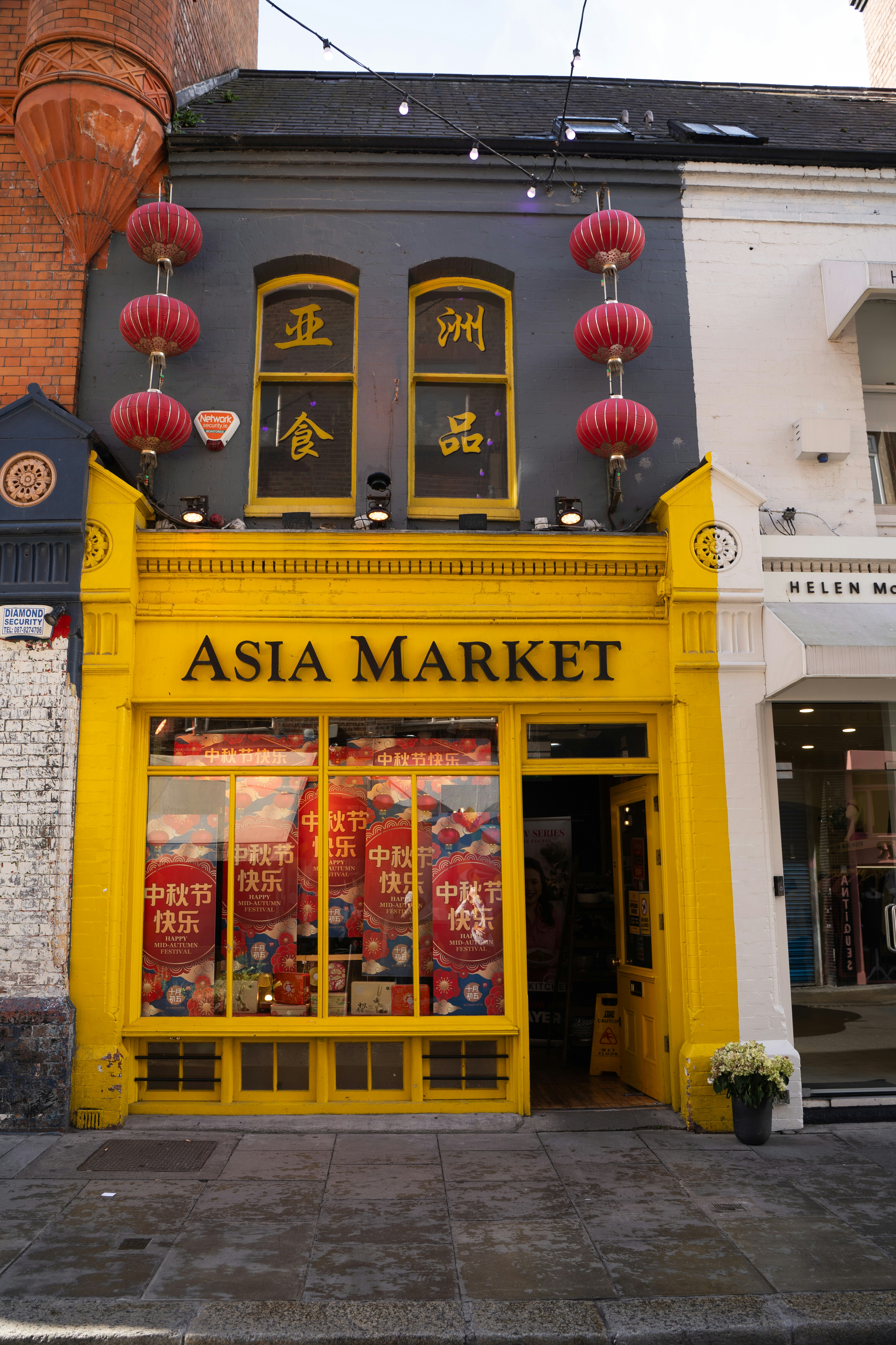 Asia market storefront with red lanterns and yellow facade