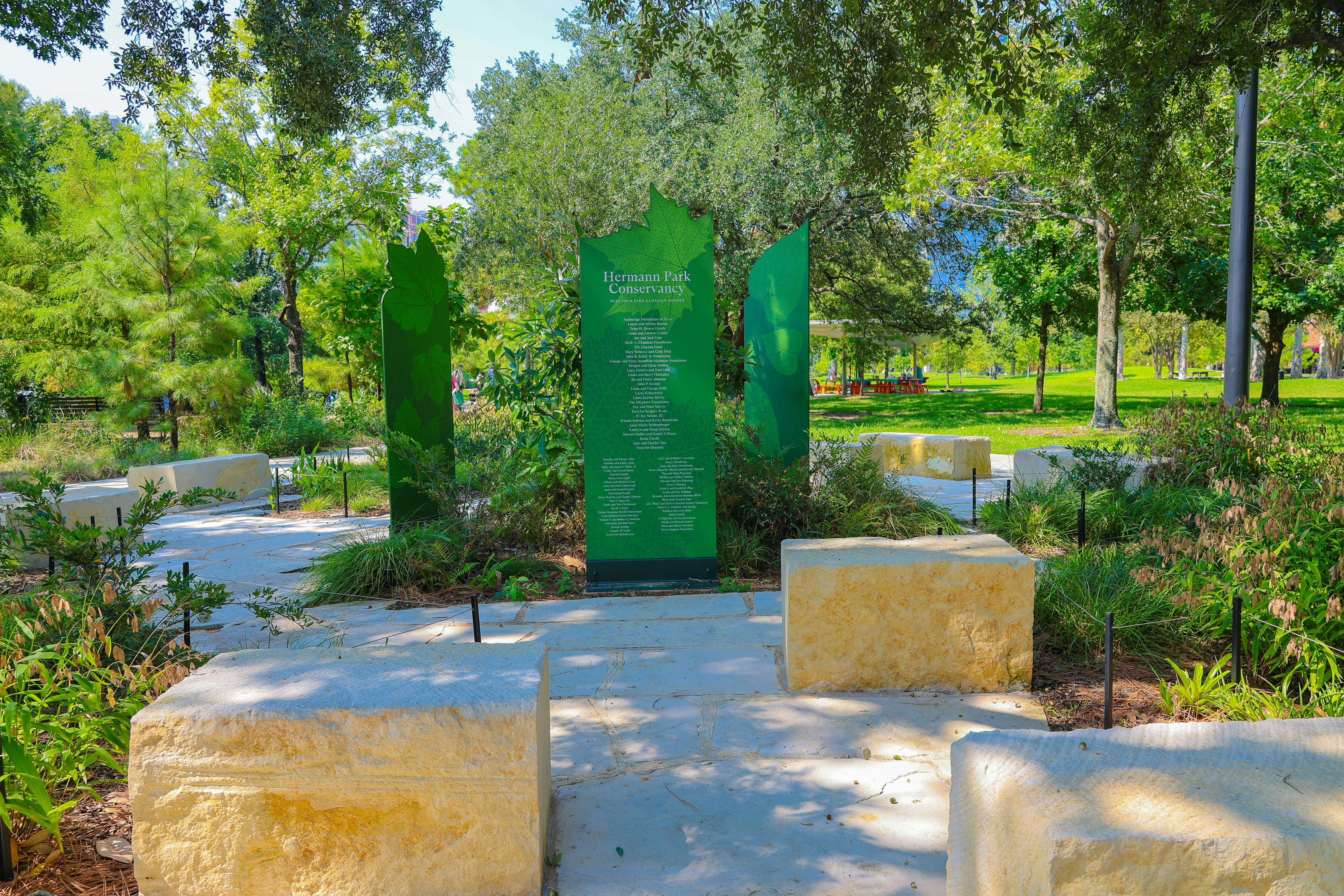 Memorial with green glass panels in a garden setting