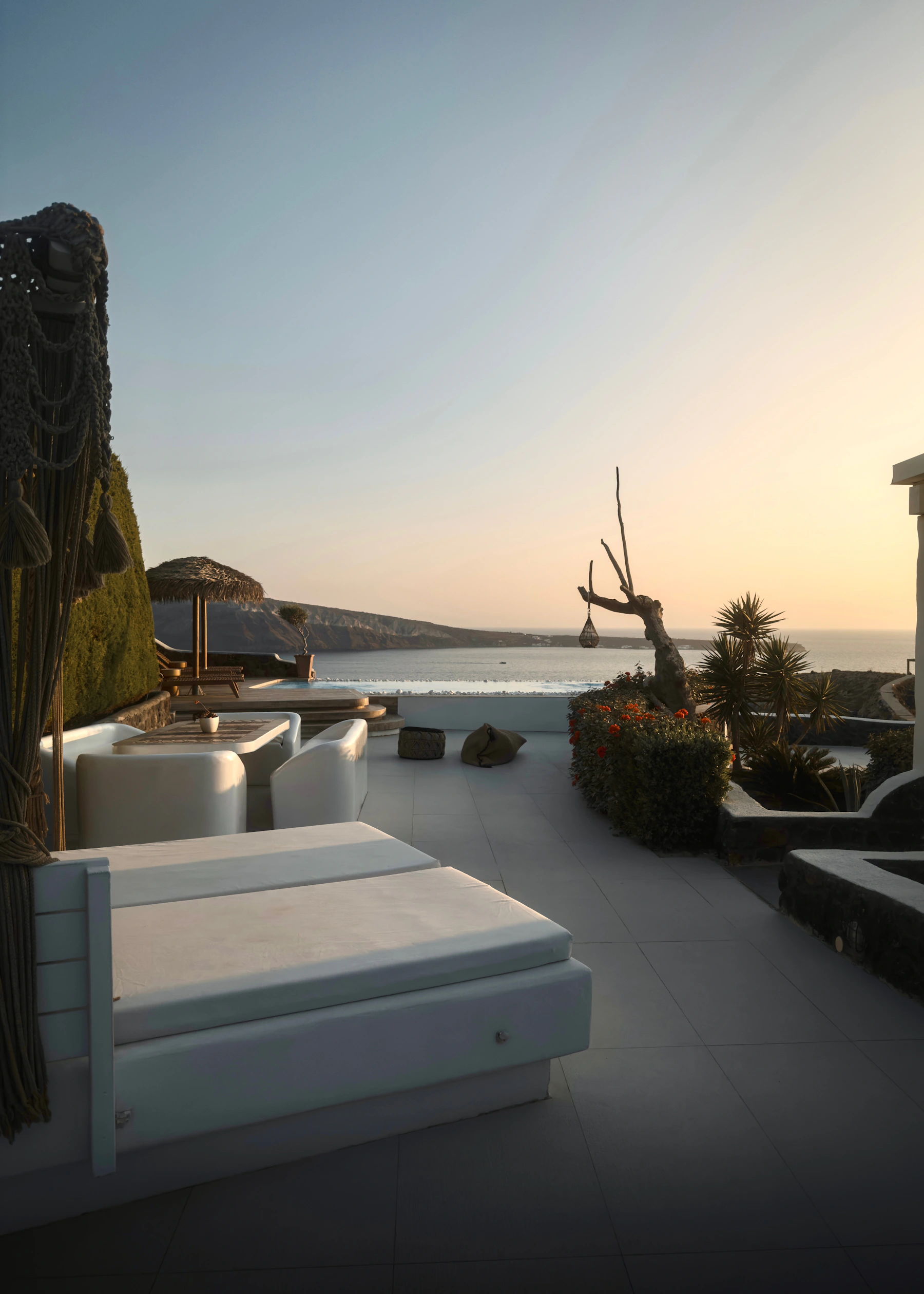 Luxury Santorini poolside lounge overlooking the sea at sunset