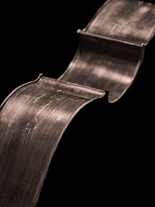 Curving metallic ribbon on black background