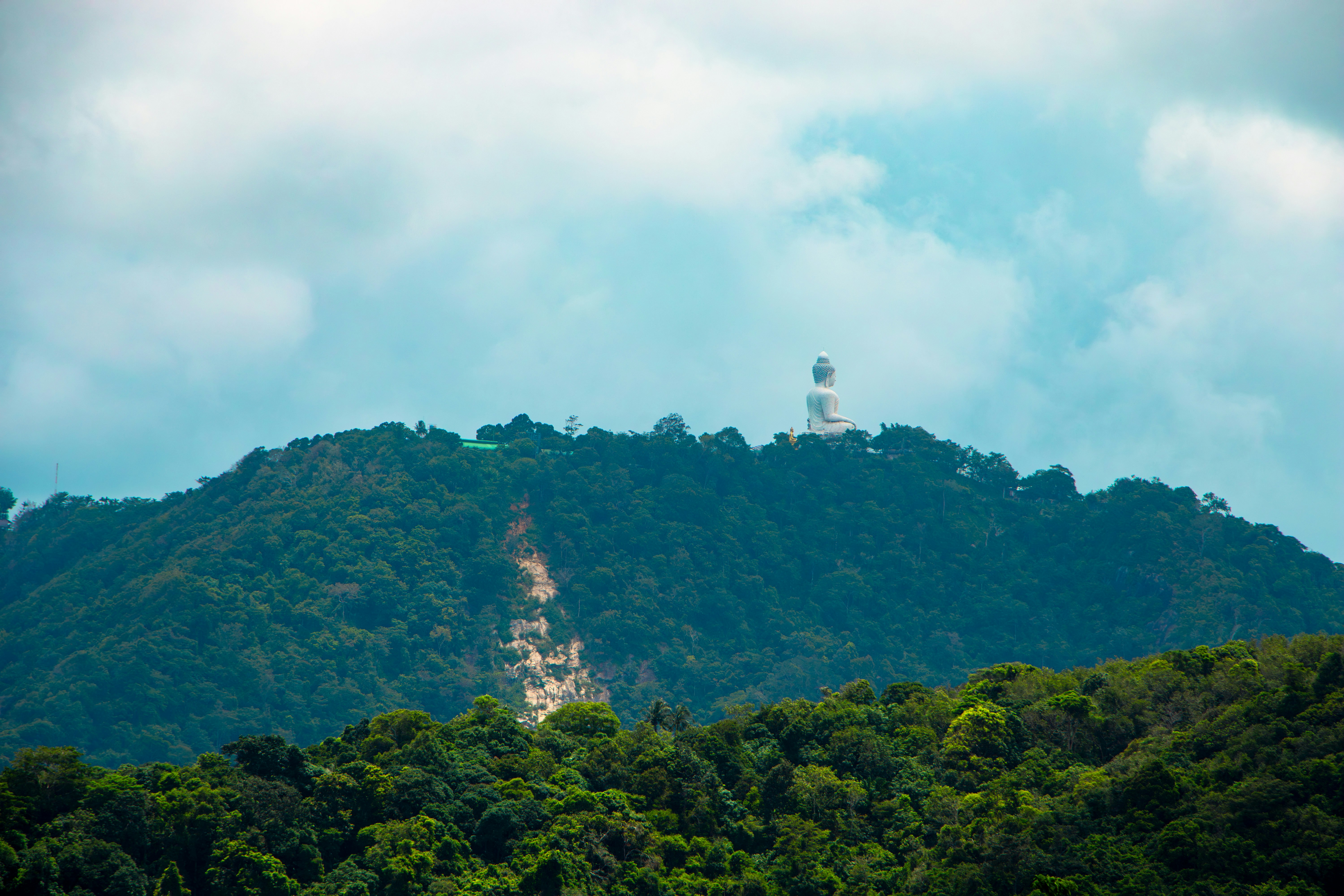 White structure atop a lush green mountain.