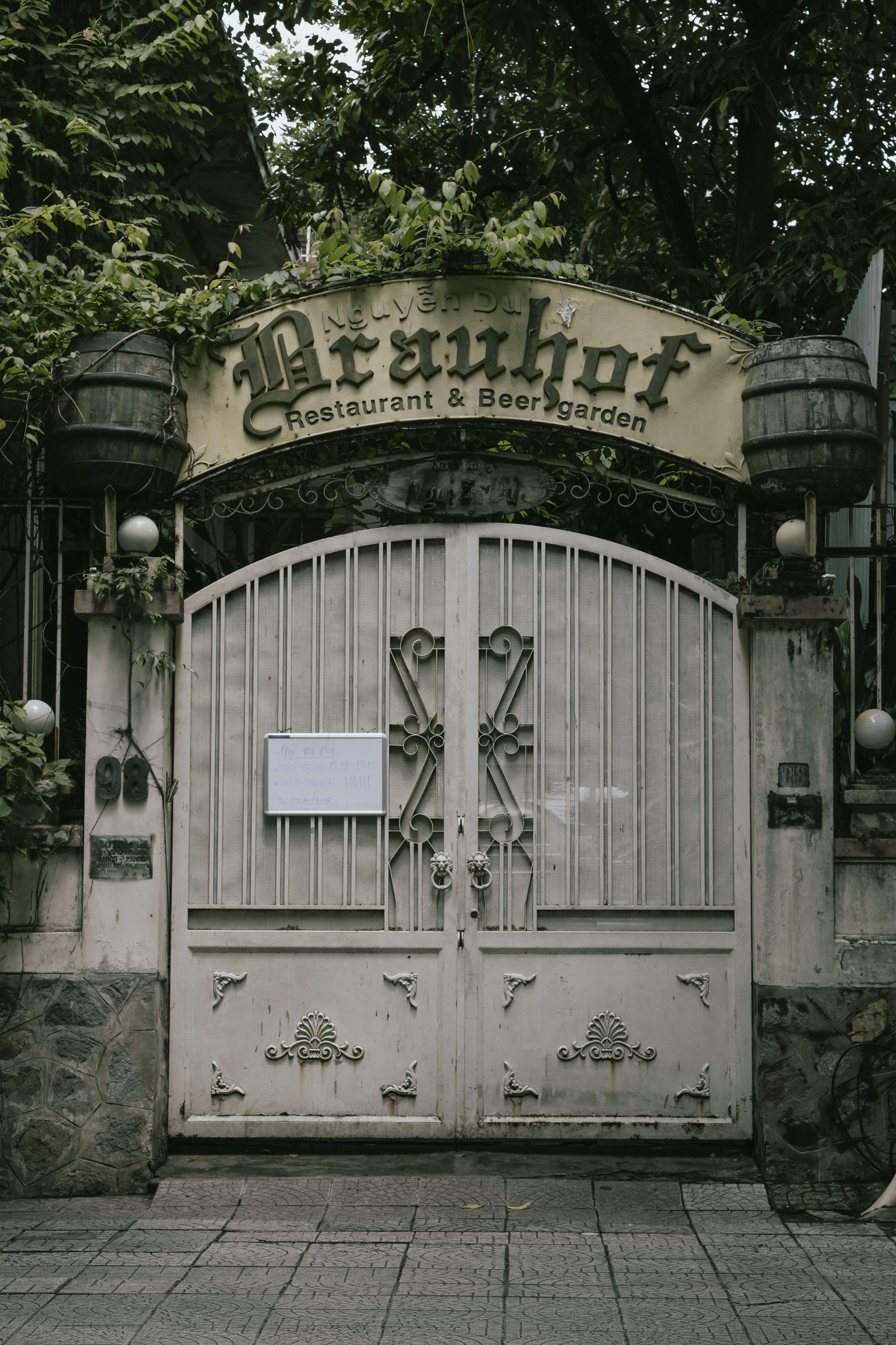 Entrada al restaurante y cervecería al aire libre con puertas ornamentadas.