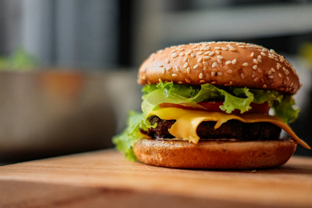 Juicy turkey burger stacked with melted cheese, crisp lettuce and tomato on a toasted brioche bun