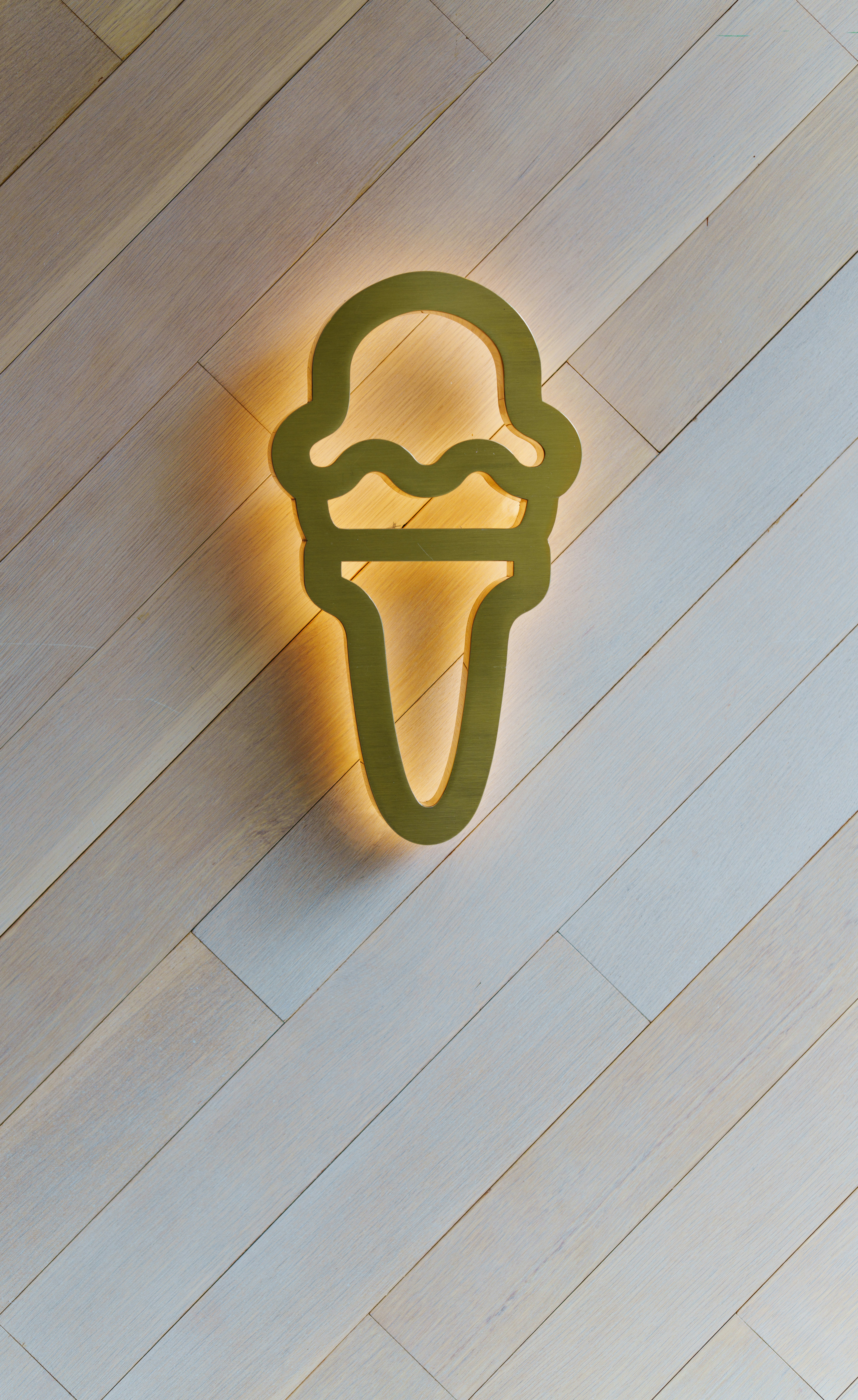 나무 벽에 빛나는 아이스크림 콘 로고.