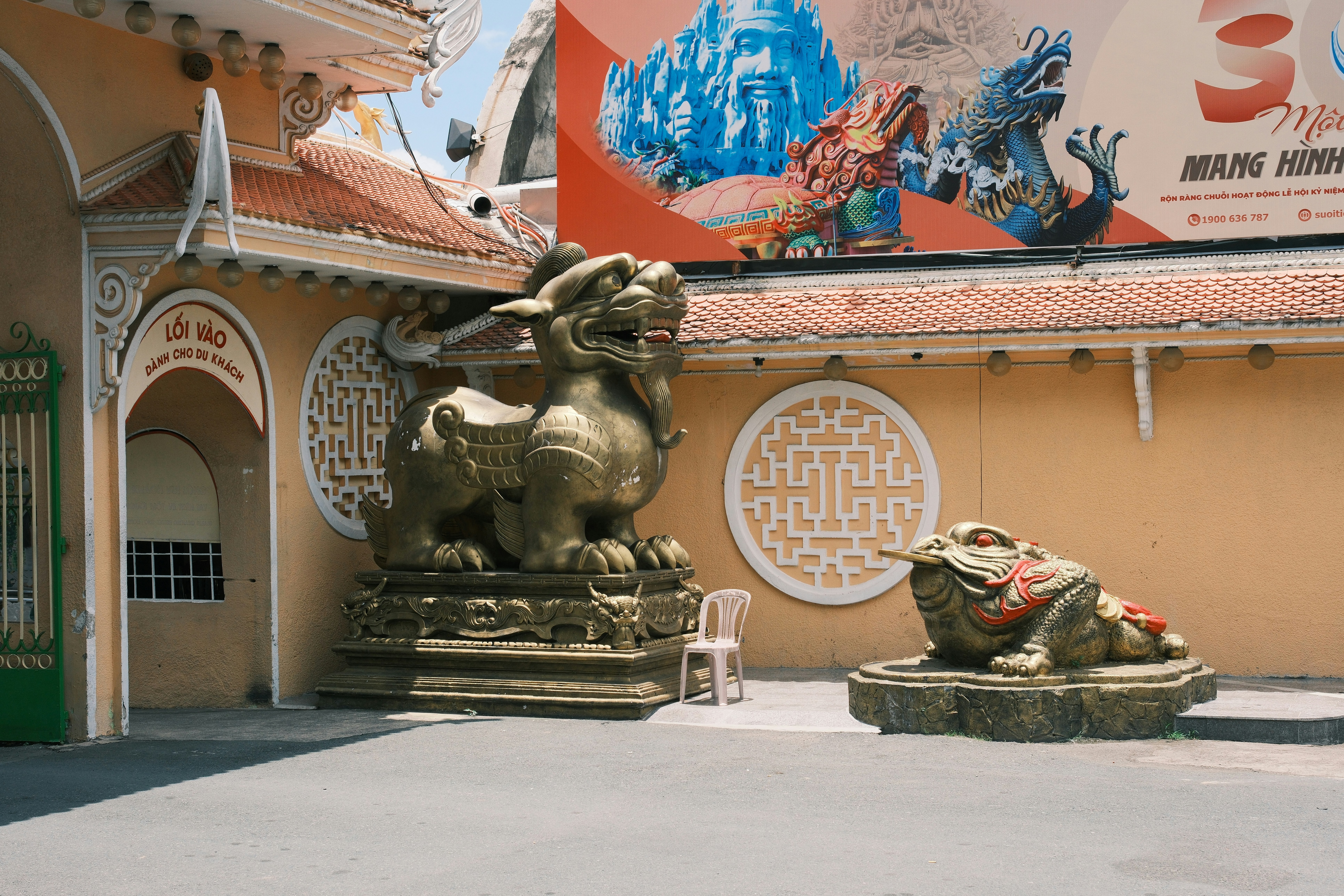 Golden lion and toad statues outside temple building