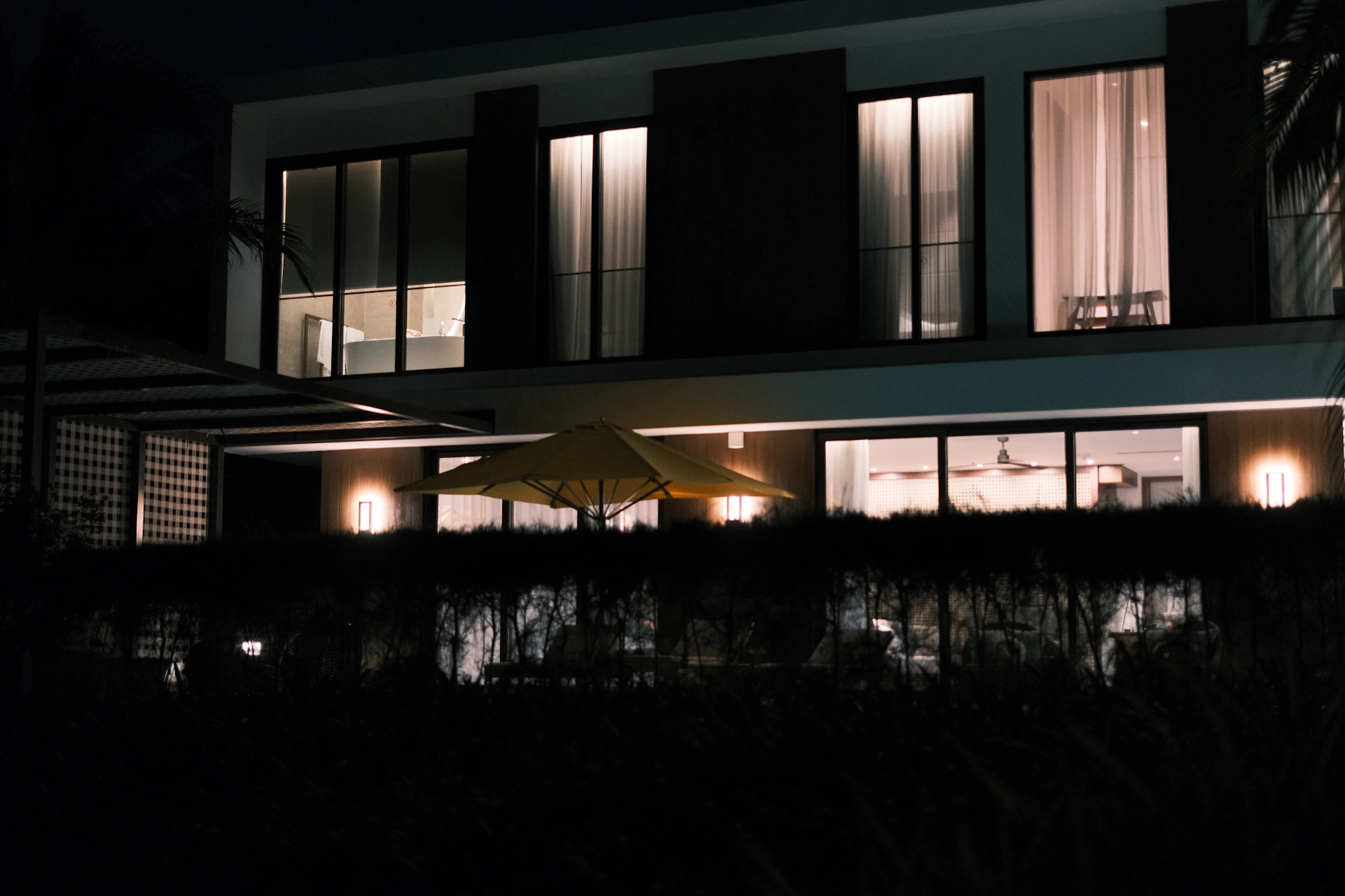 Modern house with illuminated windows at night.