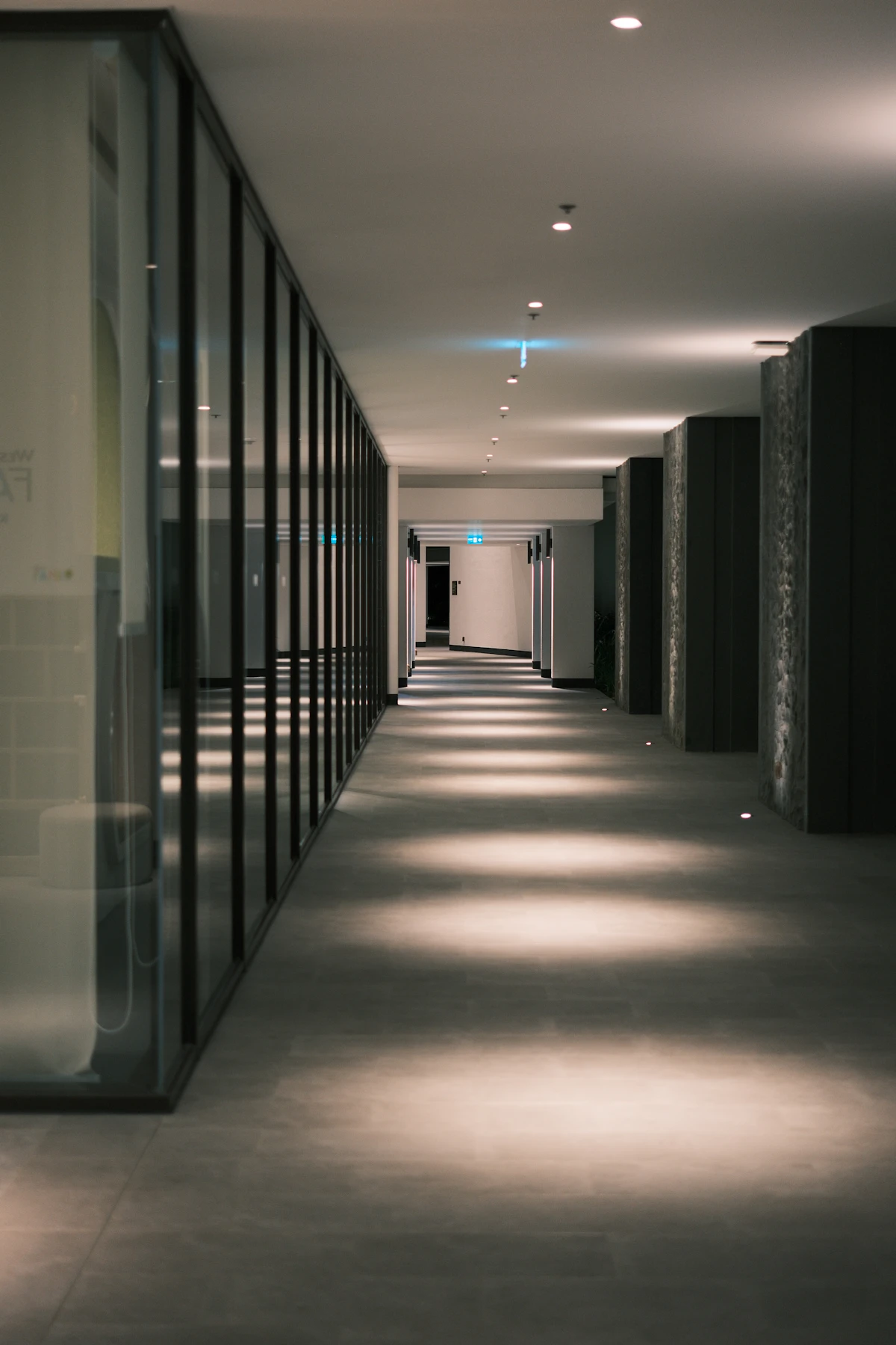 Office corridor with glass walls and lit floor