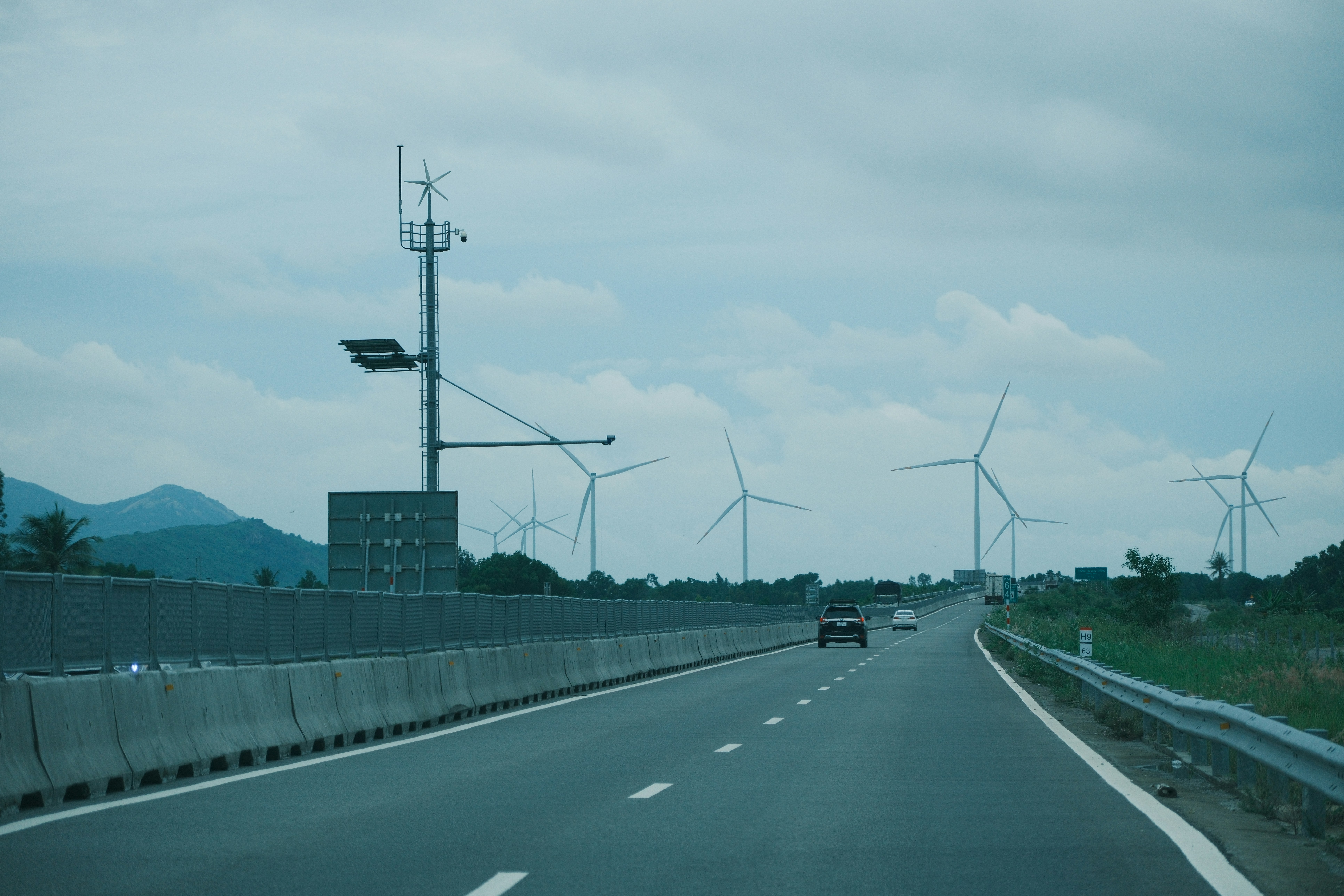Cars on highway with wind turbines in background