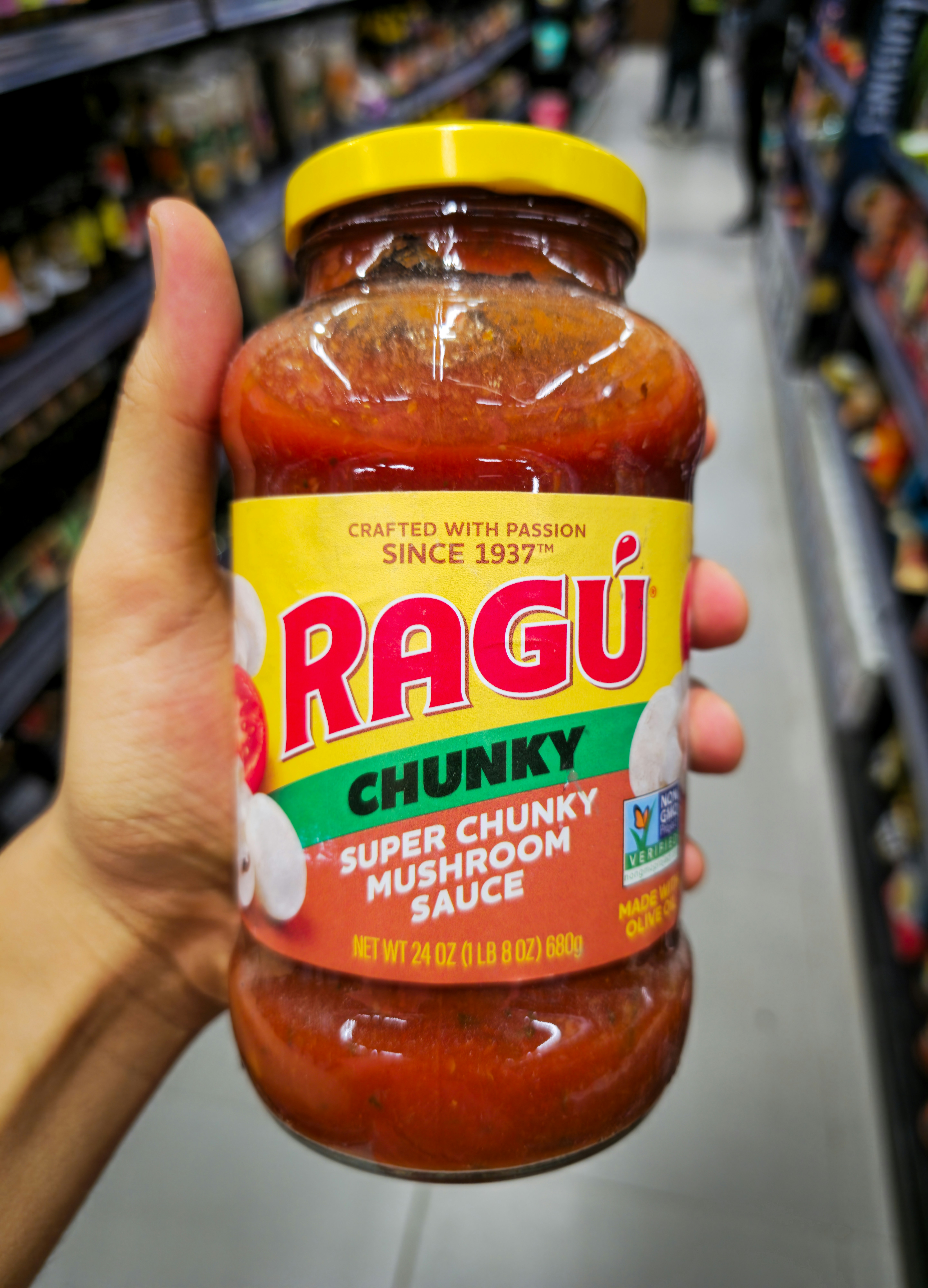 Hand holding jar of ragu chunky mushroom sauce