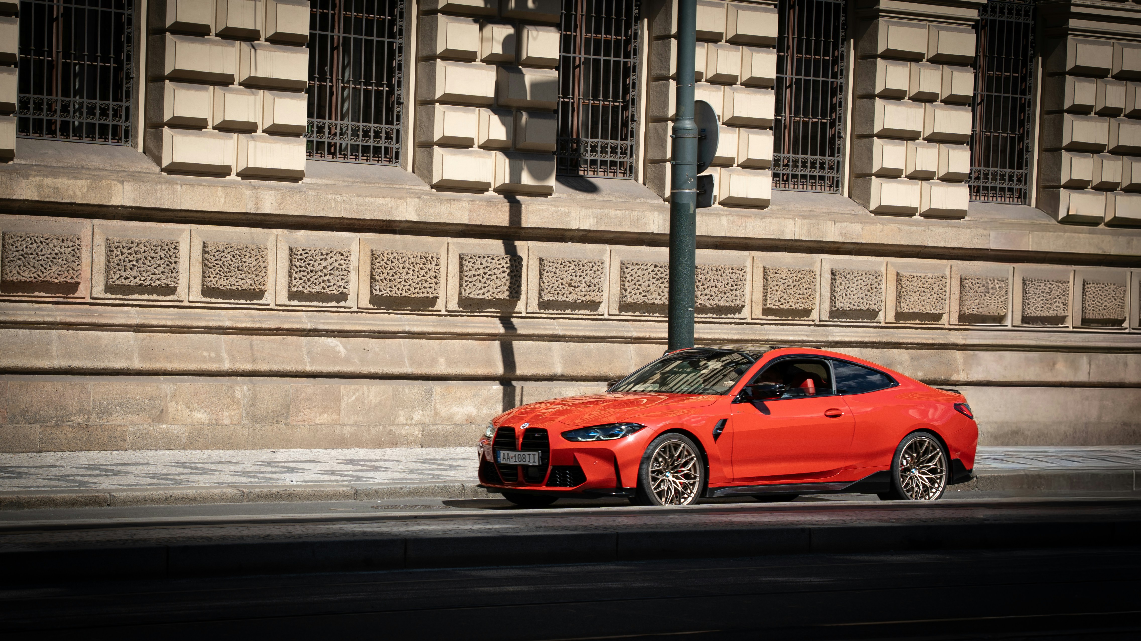 Red sports car parked on a city street.