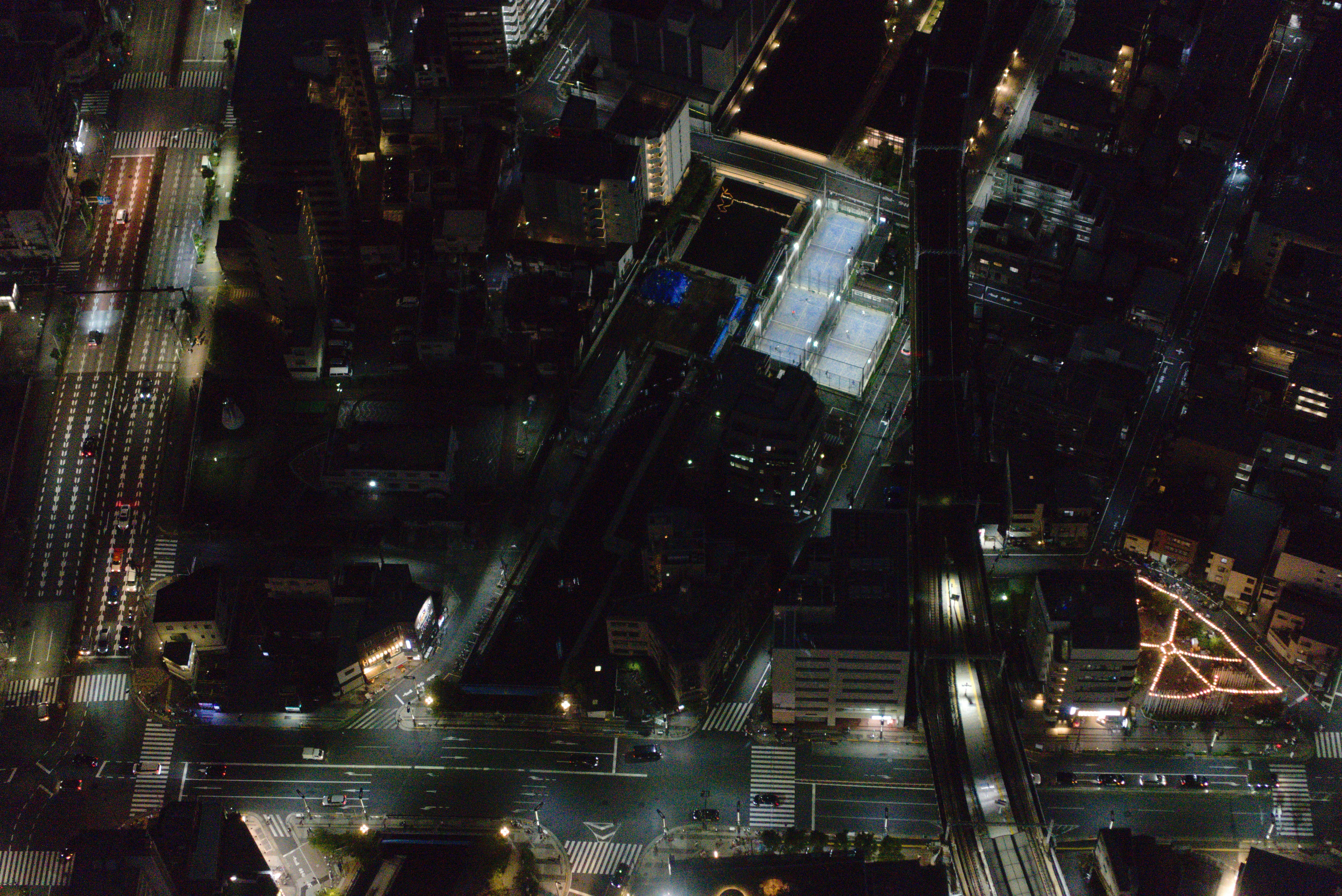 Aerial view of a city at night with illuminated buildings.