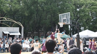 Basketball players competing in an outdoor game with spectators watching