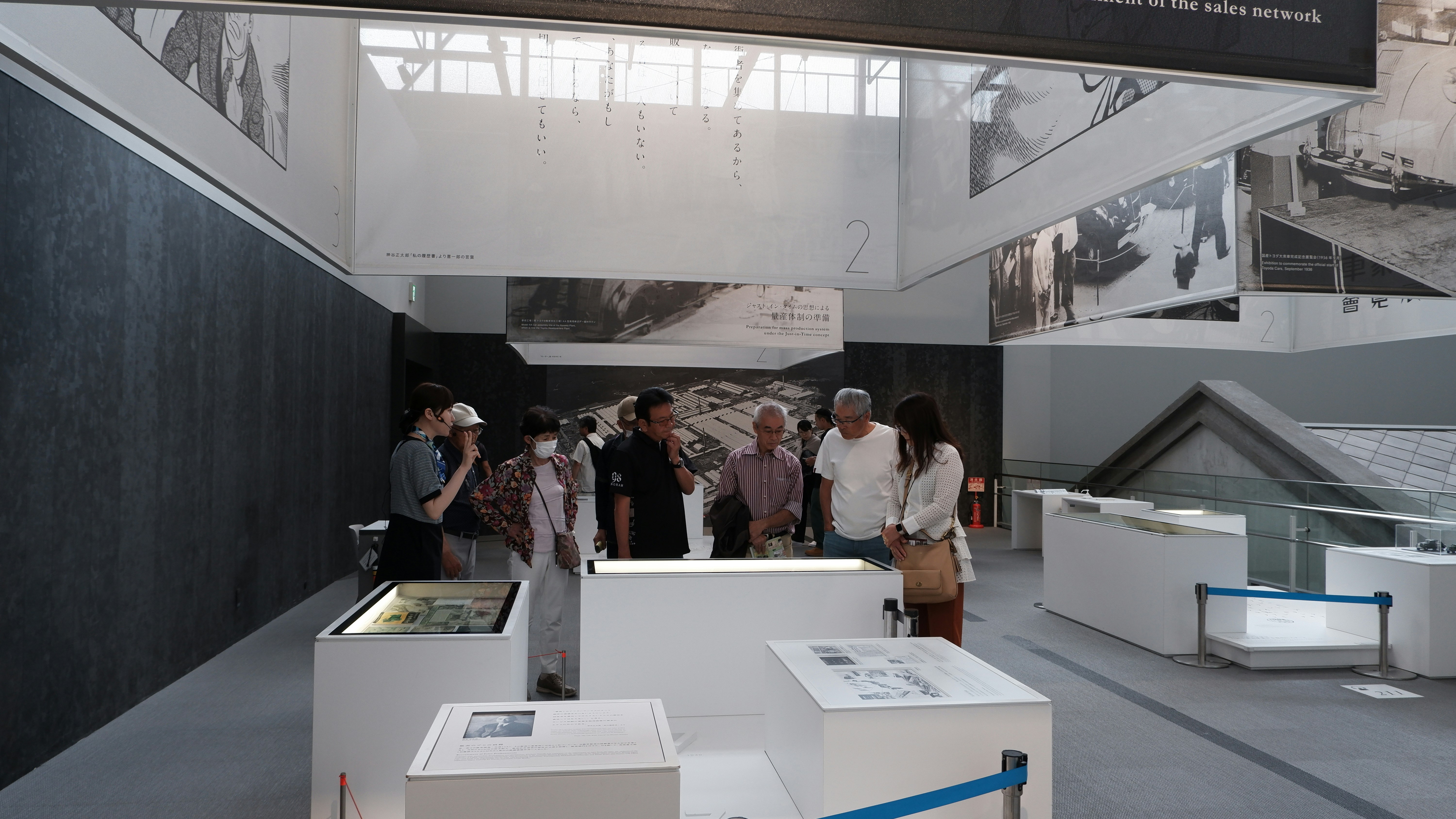 People observing exhibits in a modern museum gallery.