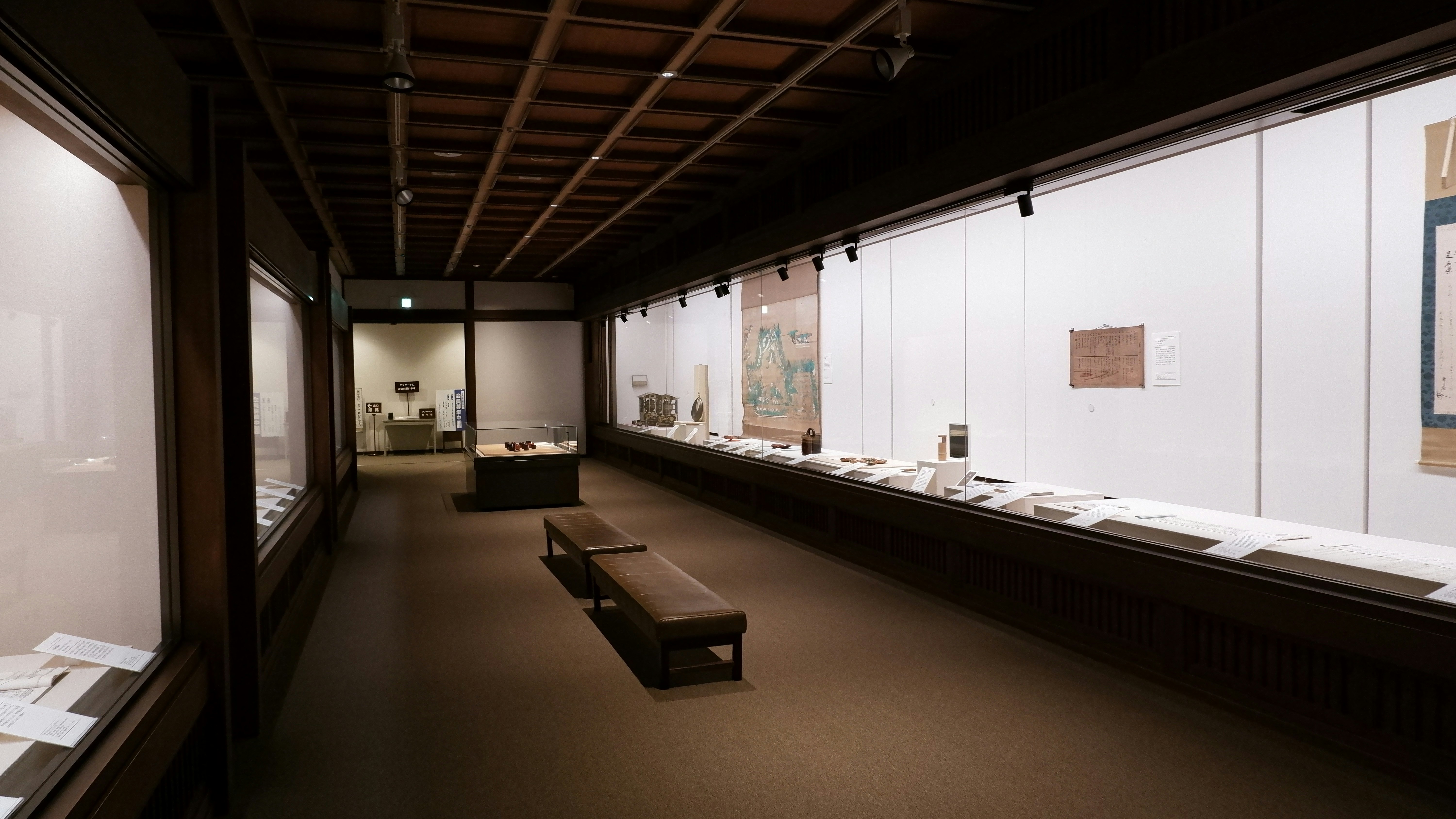 An art gallery hallway with displays and benches.