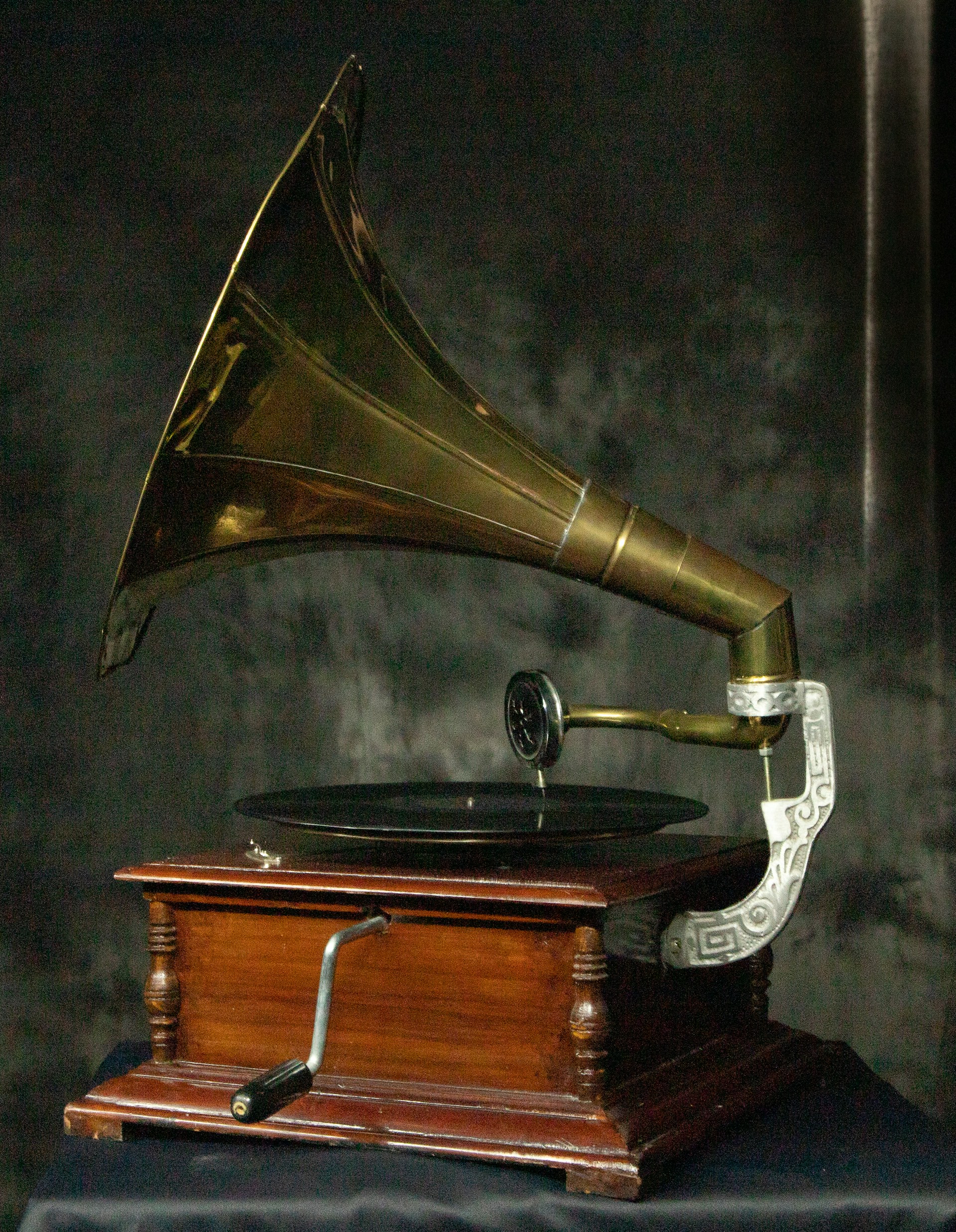 Antique gramophone with wooden base and brass horn.