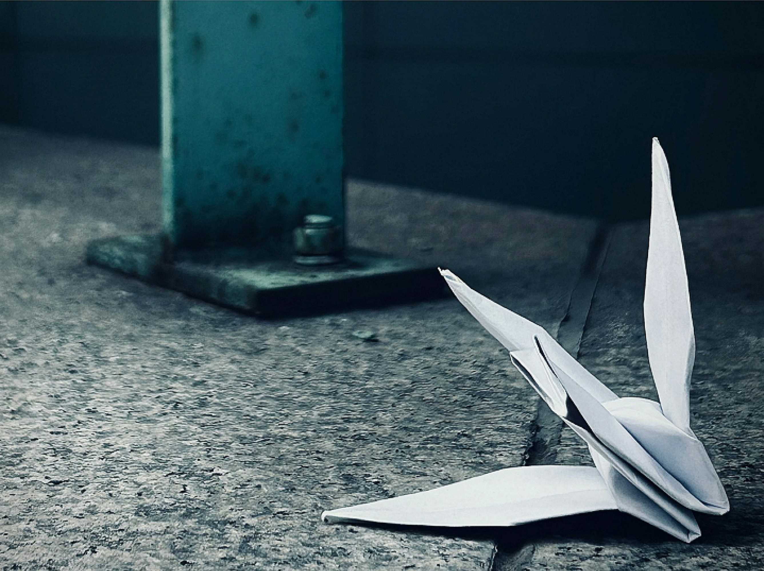 Paper crane placed on a stone floor