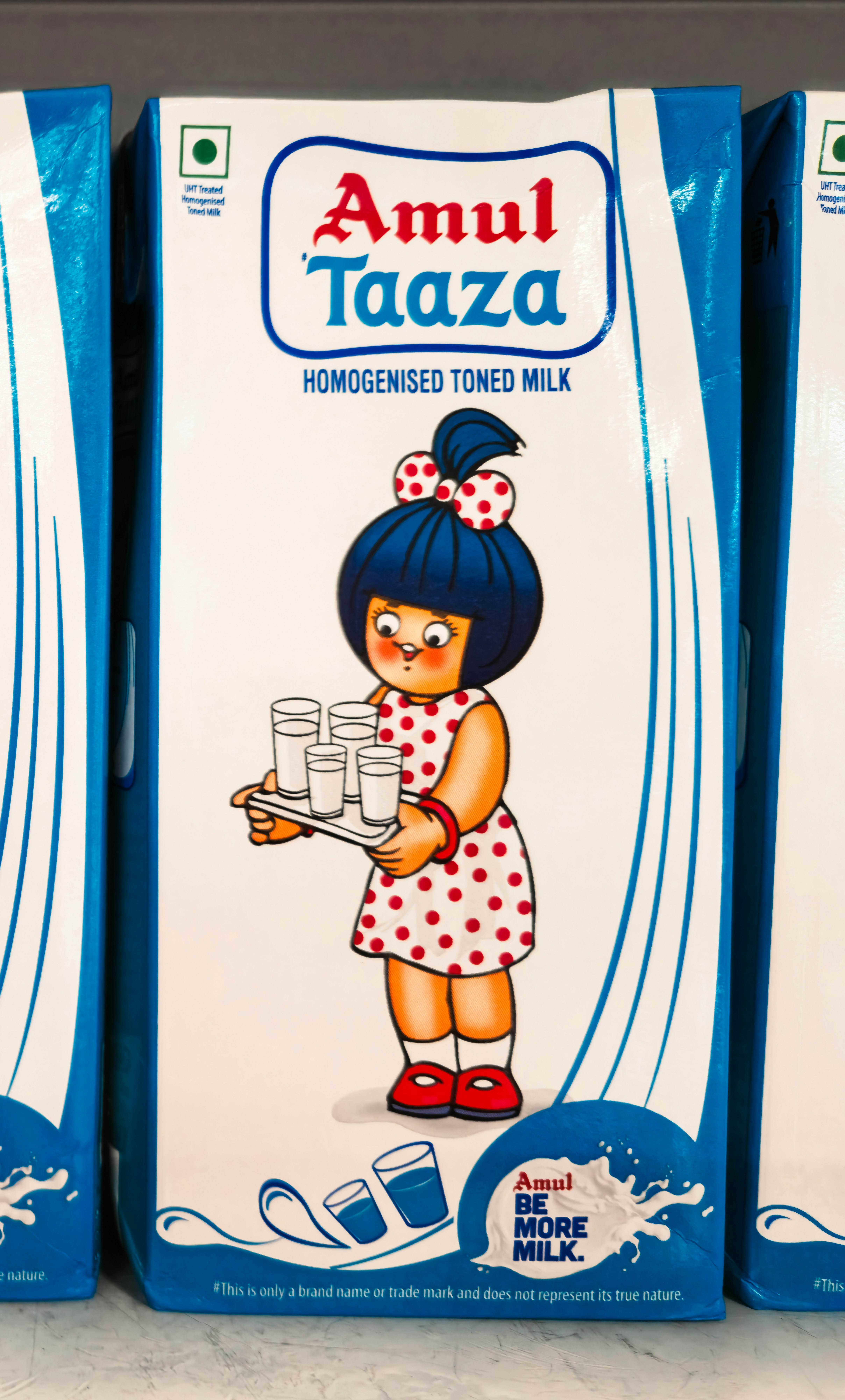 Amul taaza milk carton with a girl holding glasses