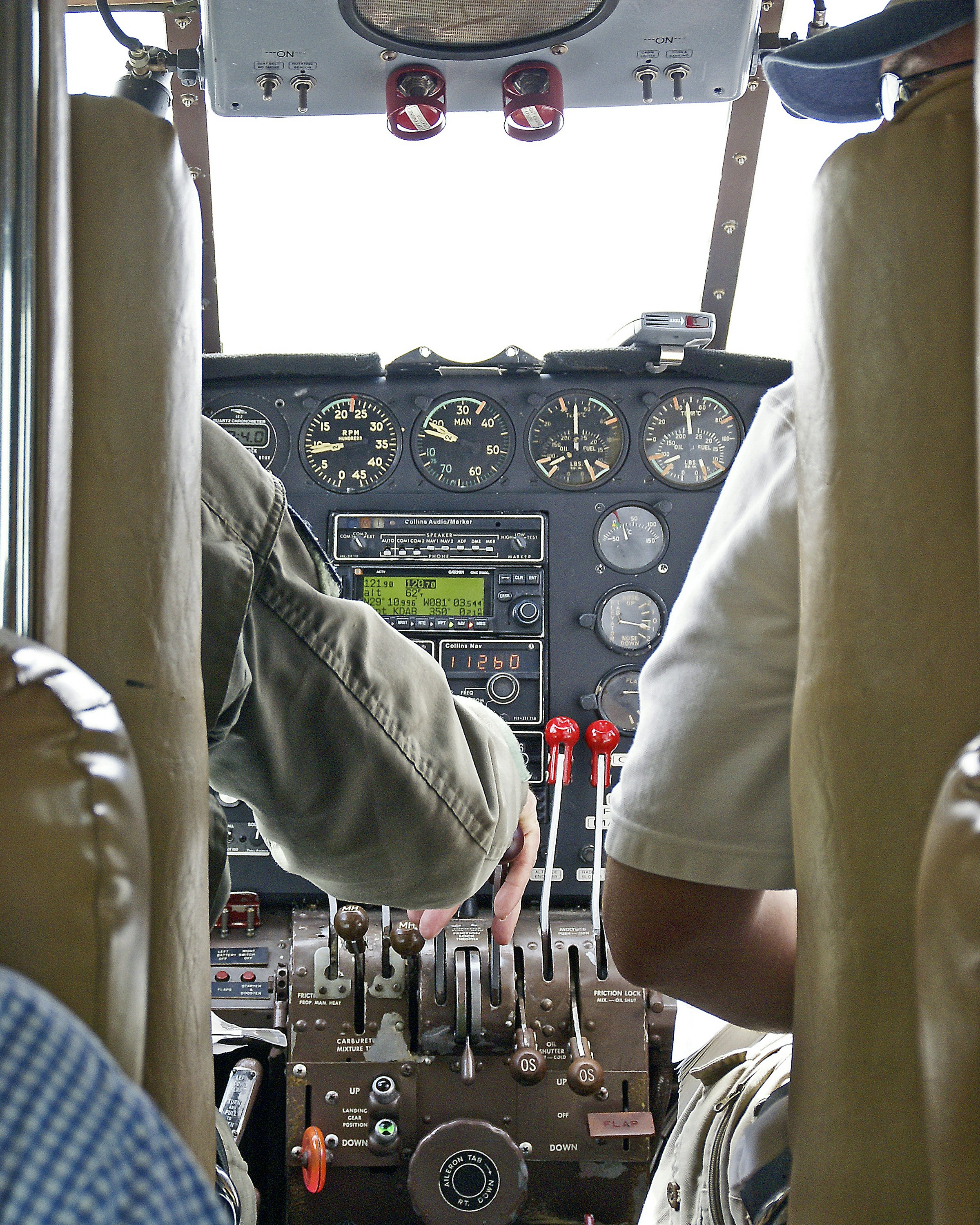 Pilots hands operating aircraft controls and dashboard