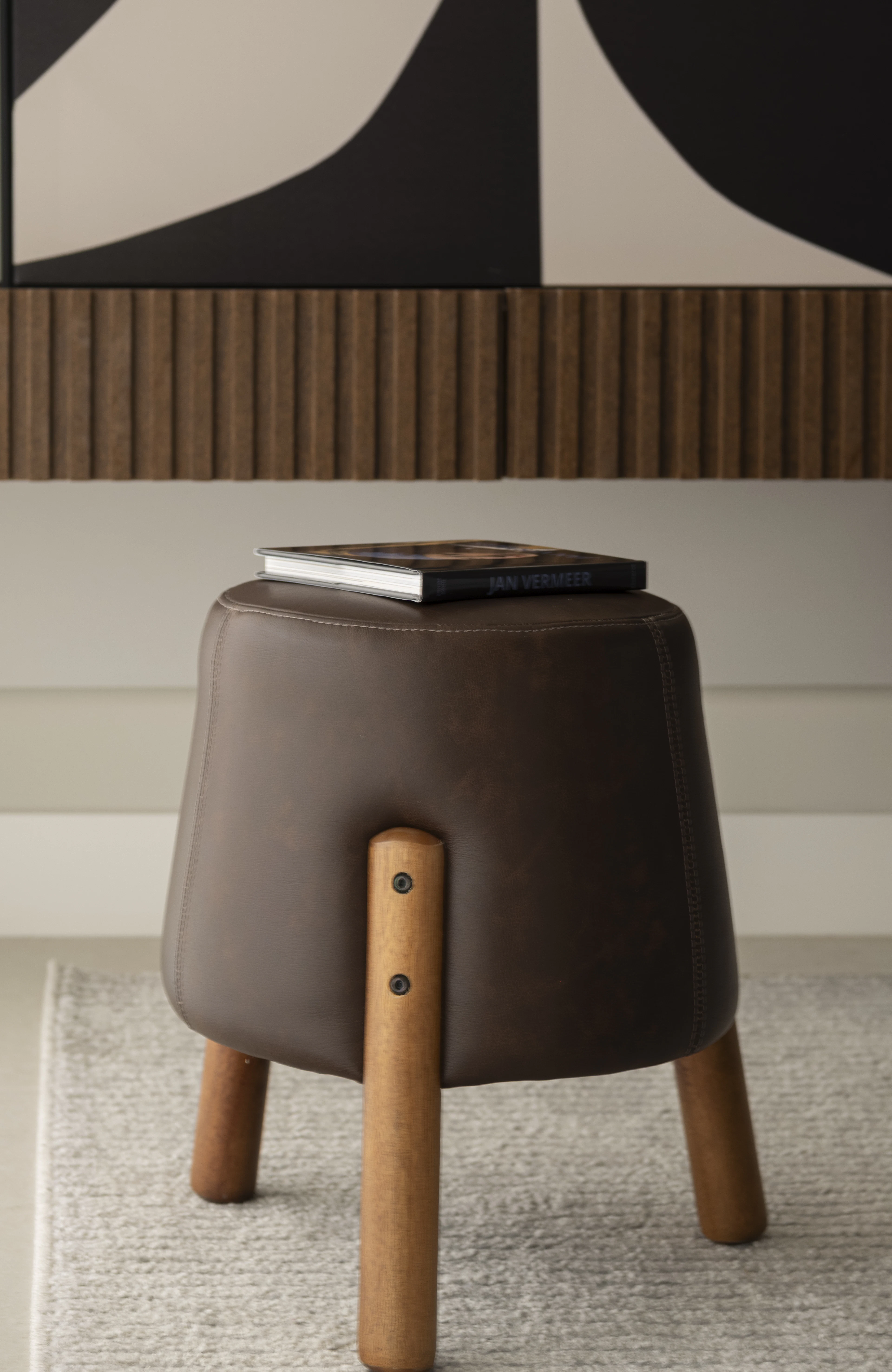 Leather stool with oak legs and a book