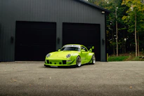 Bright green sports car parked in front of garage.