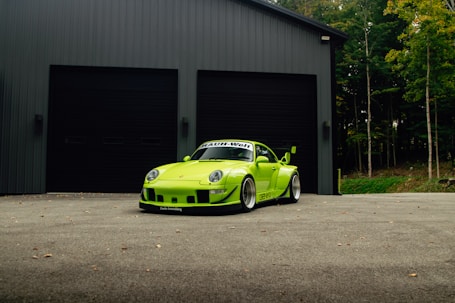 Bright green sports car parked in front of garage.