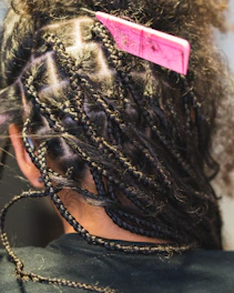 A person getting box braids done