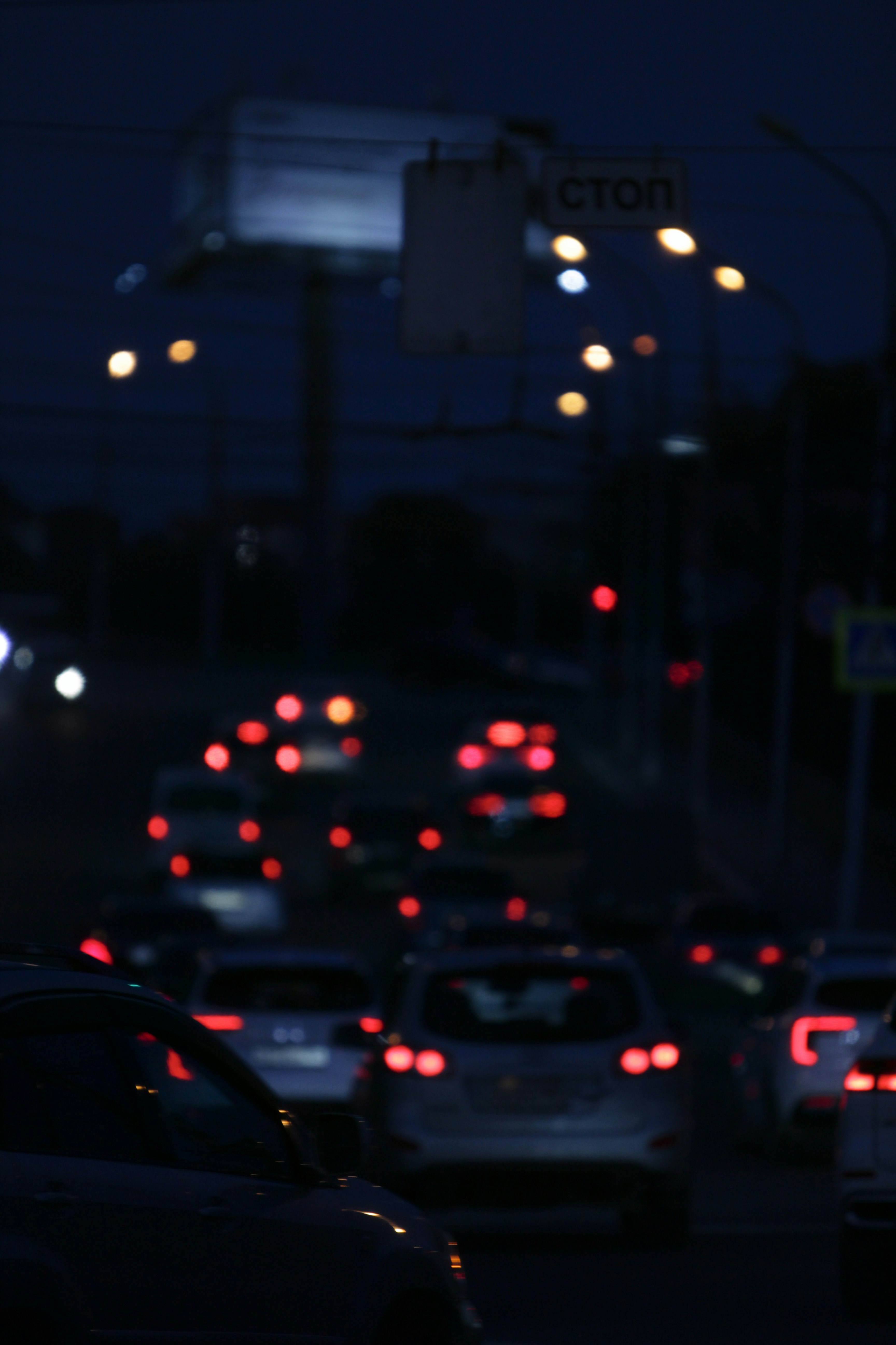 Cars in traffic at night with blurred lights.