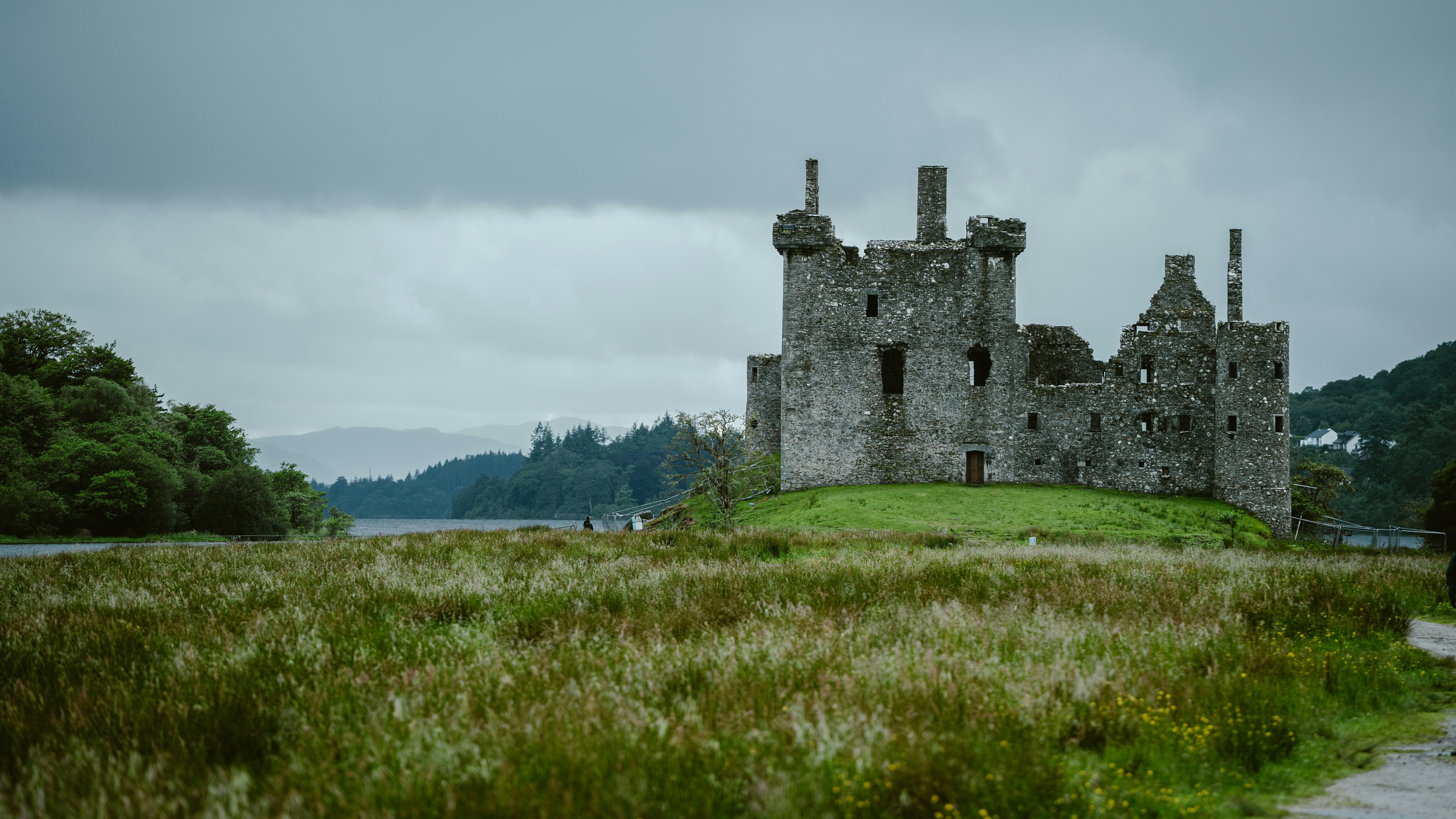 Ancient stone castle ruins on a grassy hill.