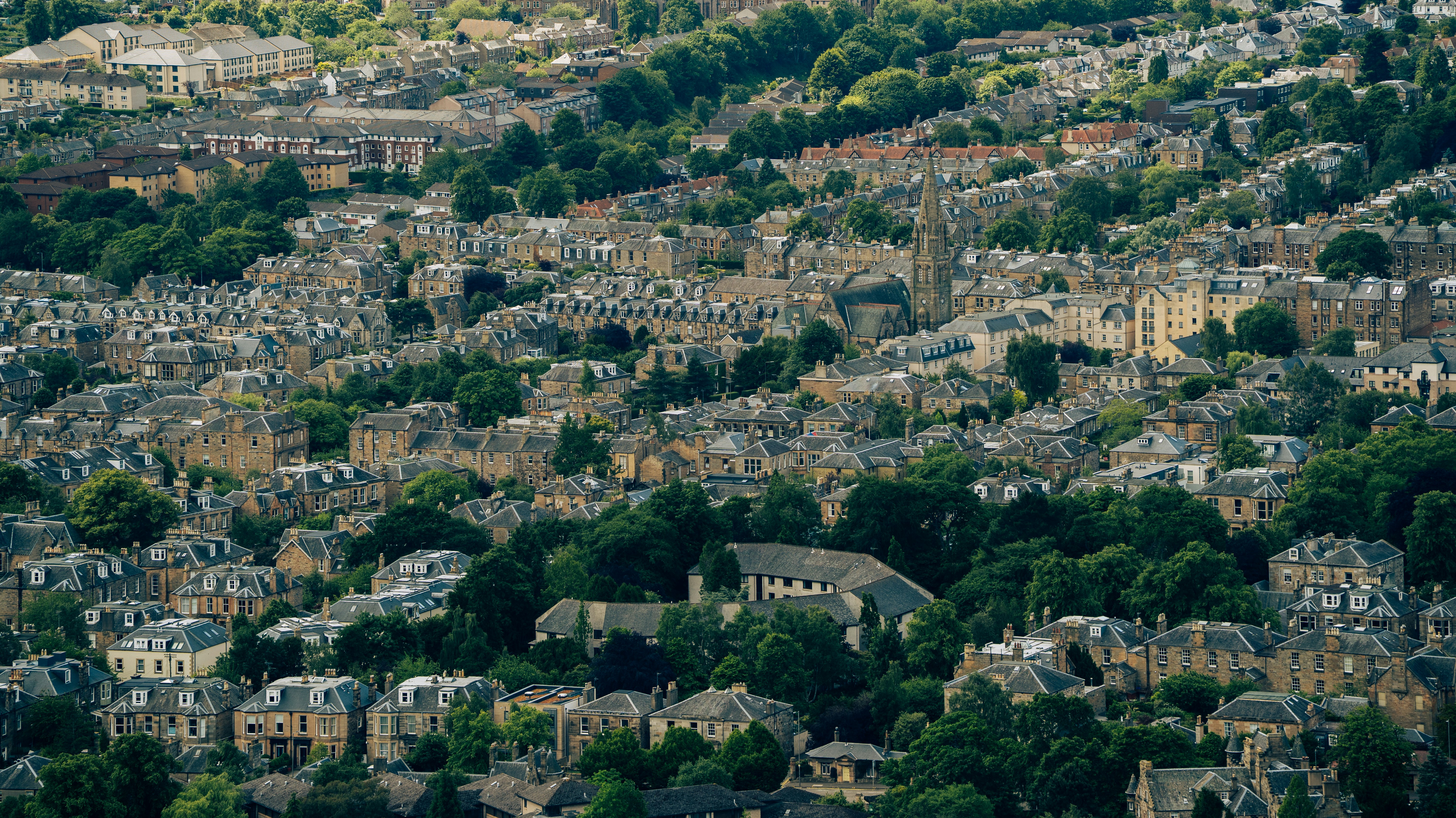 Dense residential buildings nestled among green trees.