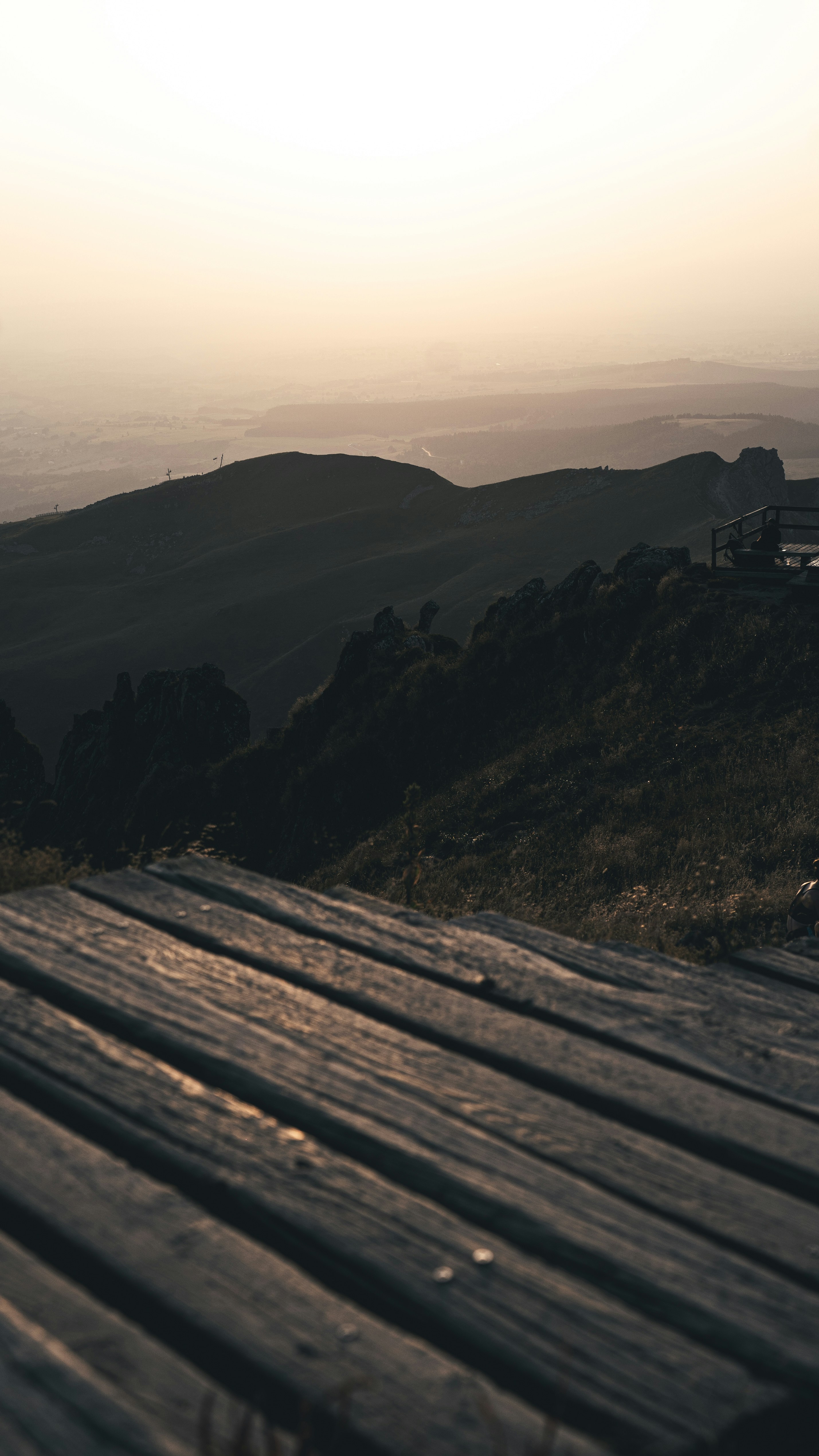 Wooden walkway overlooking misty mountains at sunrise