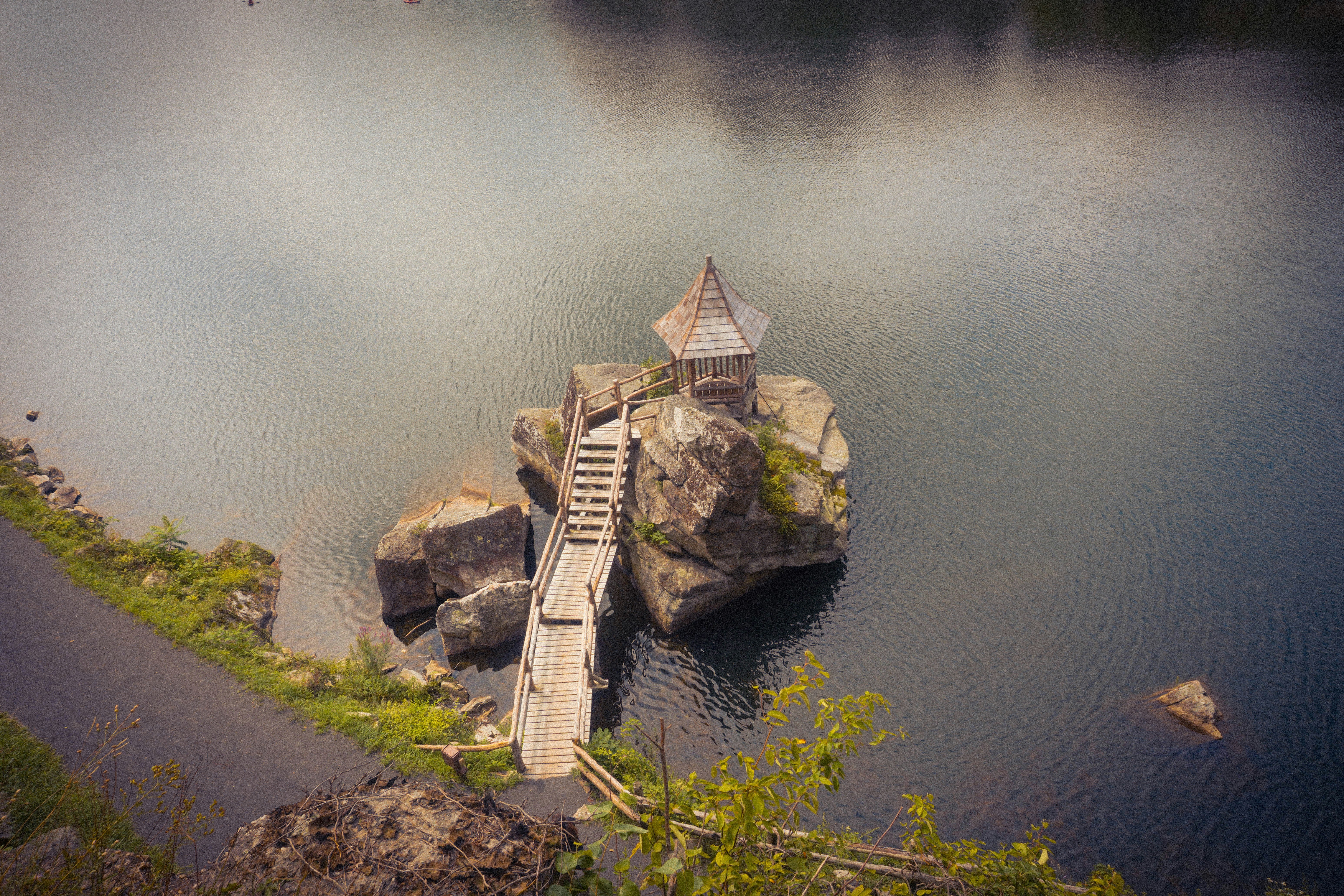 Small gazebo on a rock in the water.