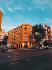 Orange building on a city street at dusk