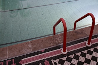Red ladder leads into a swimming pool