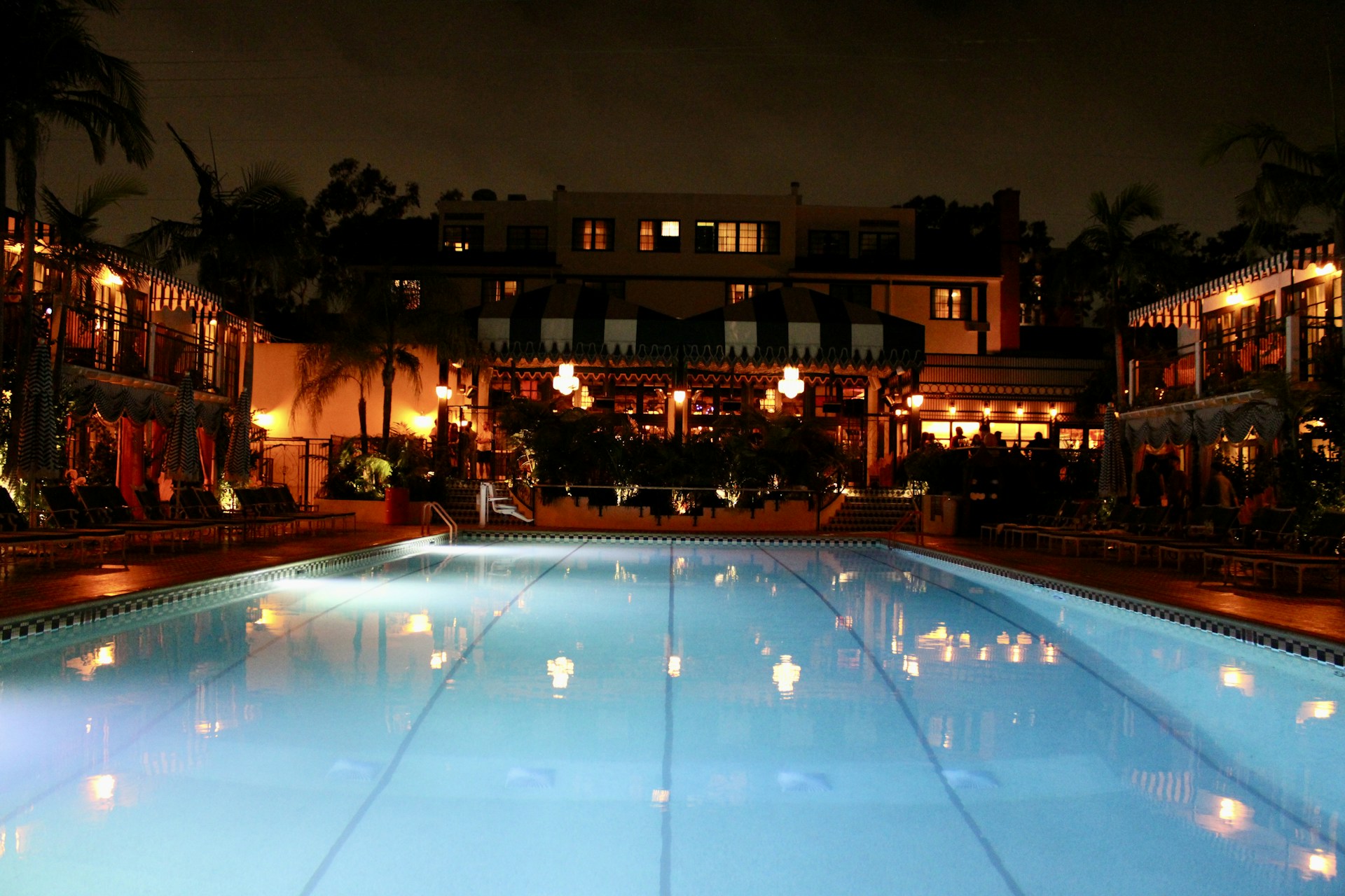 Illuminated swimming pool at a hotel at night.