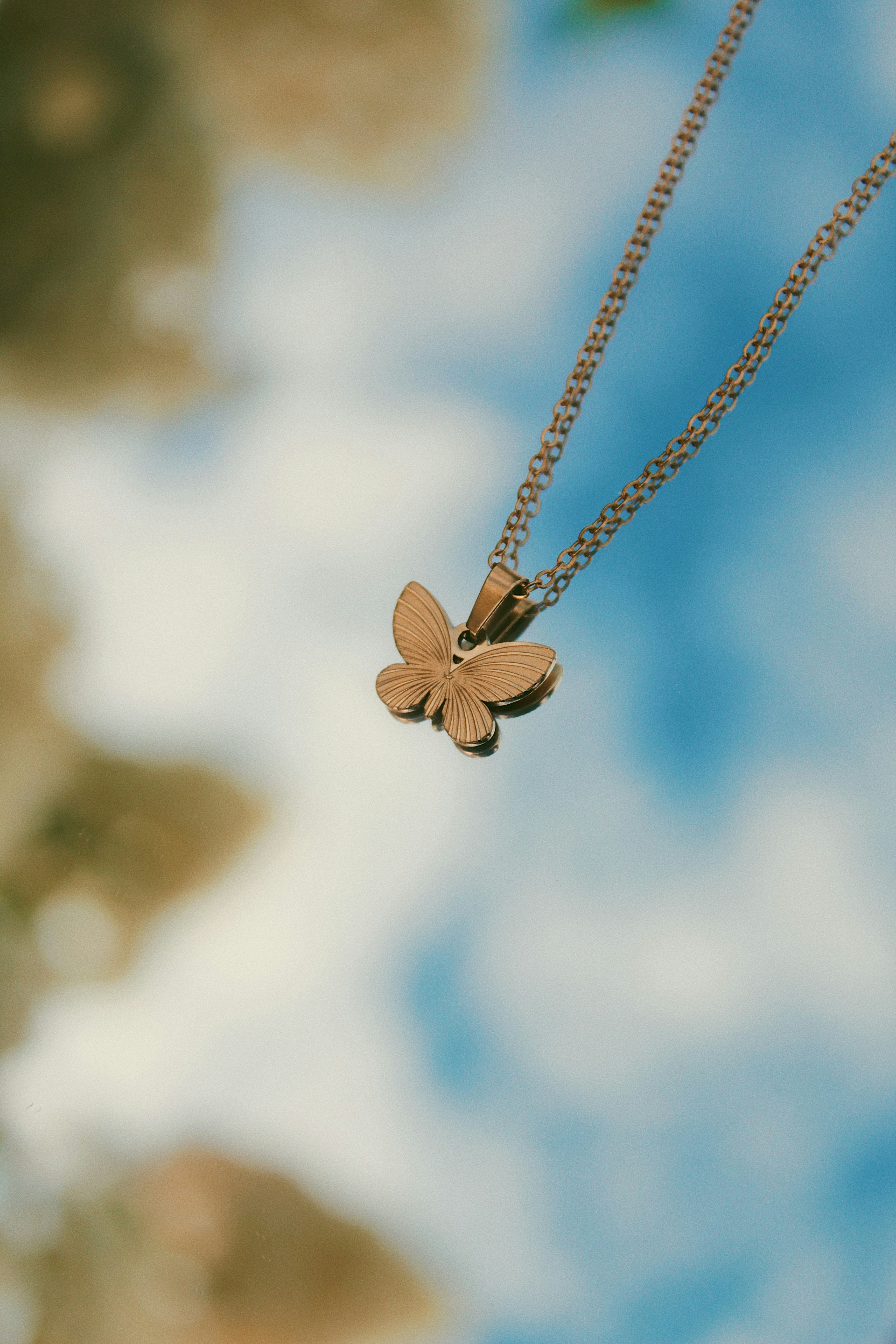 A delicate butterfly necklace on a chain.