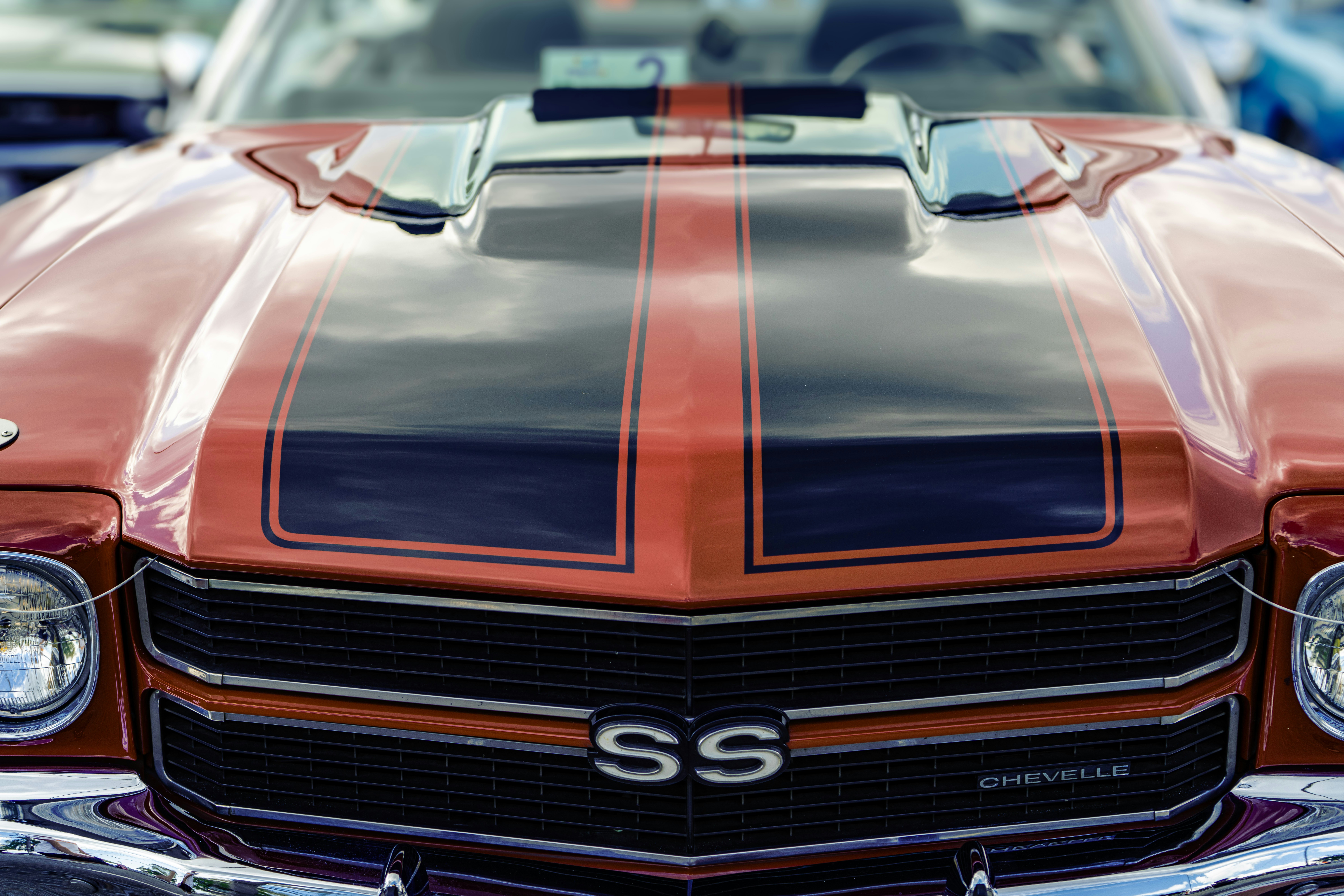Red vintage car with black racing stripes