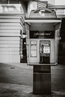 Vintage payphone booth with 'free calls here' sign.