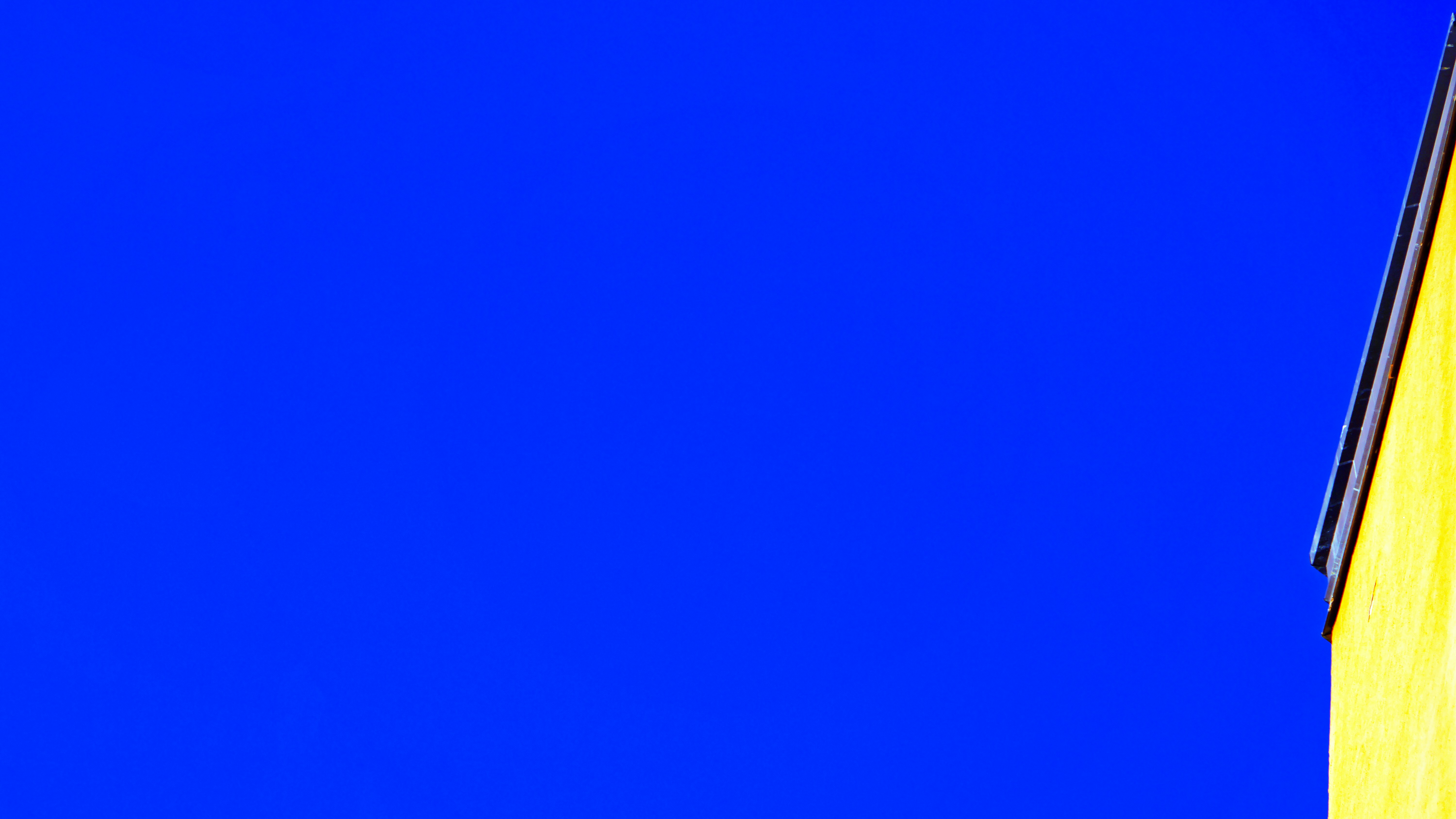 Yellow building corner against blue sky