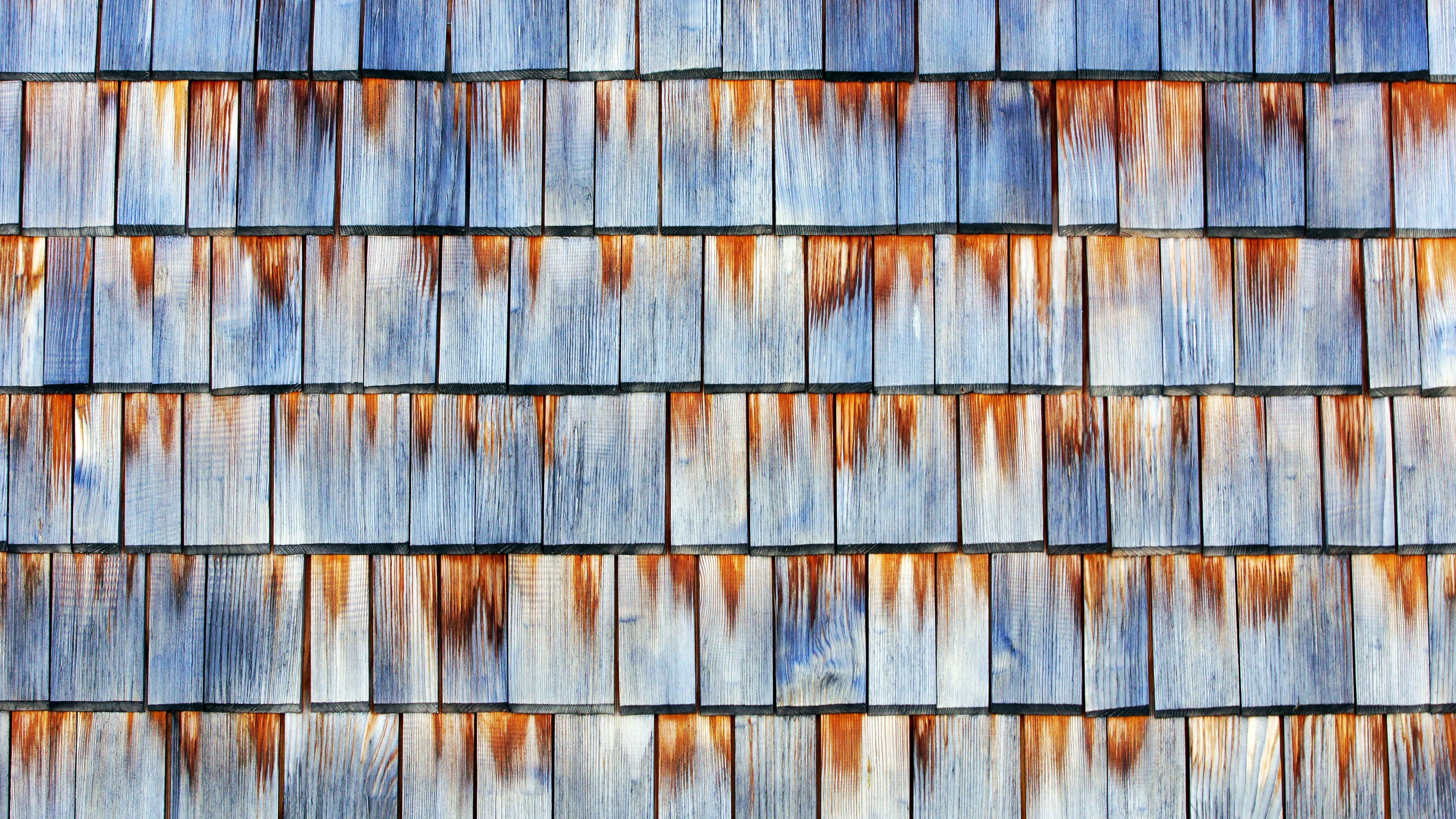 Rotted cedar shingles with visible moisture damage, warping, and curling - replacing cedar shingles