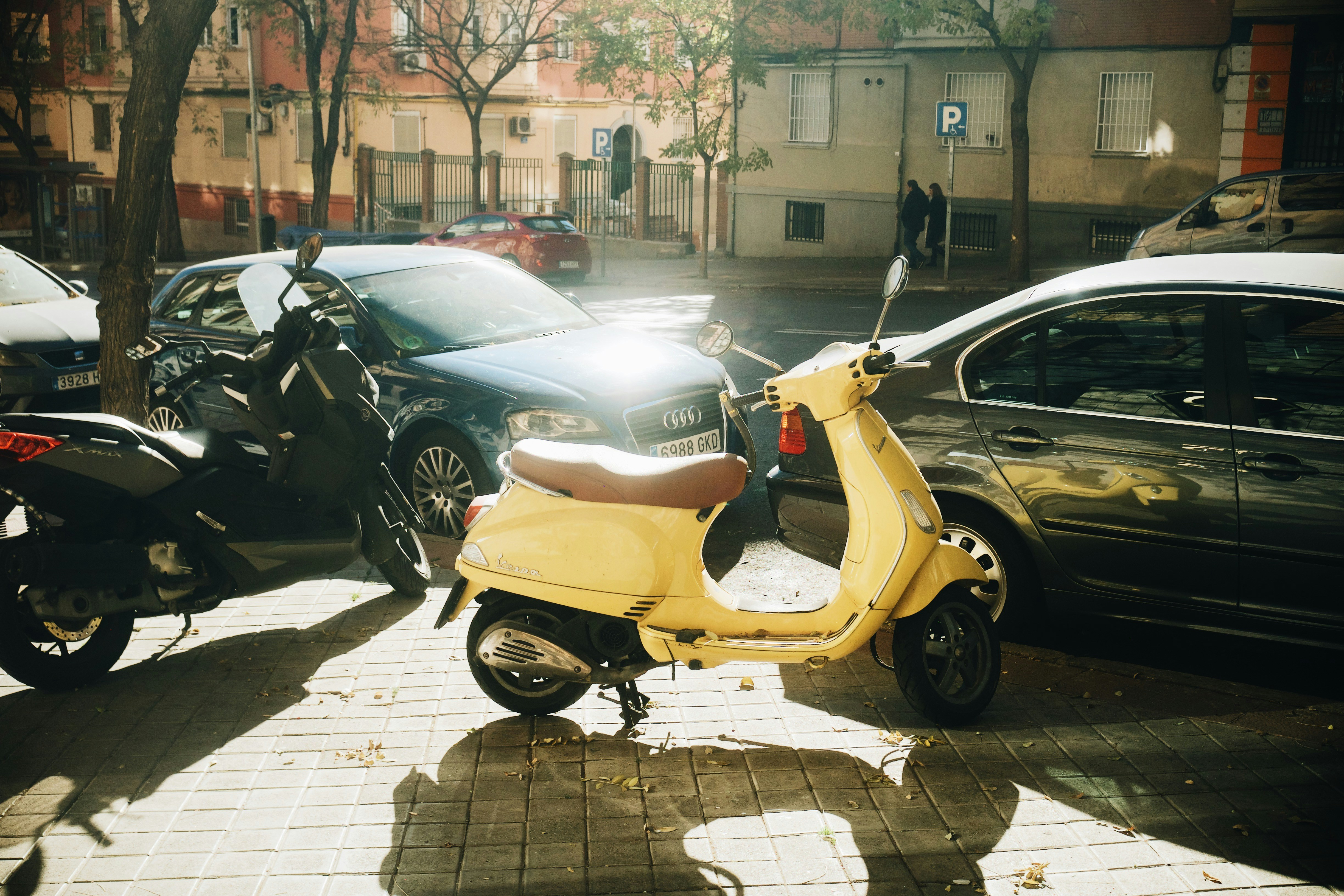Yellow scooter parked on a sunny street