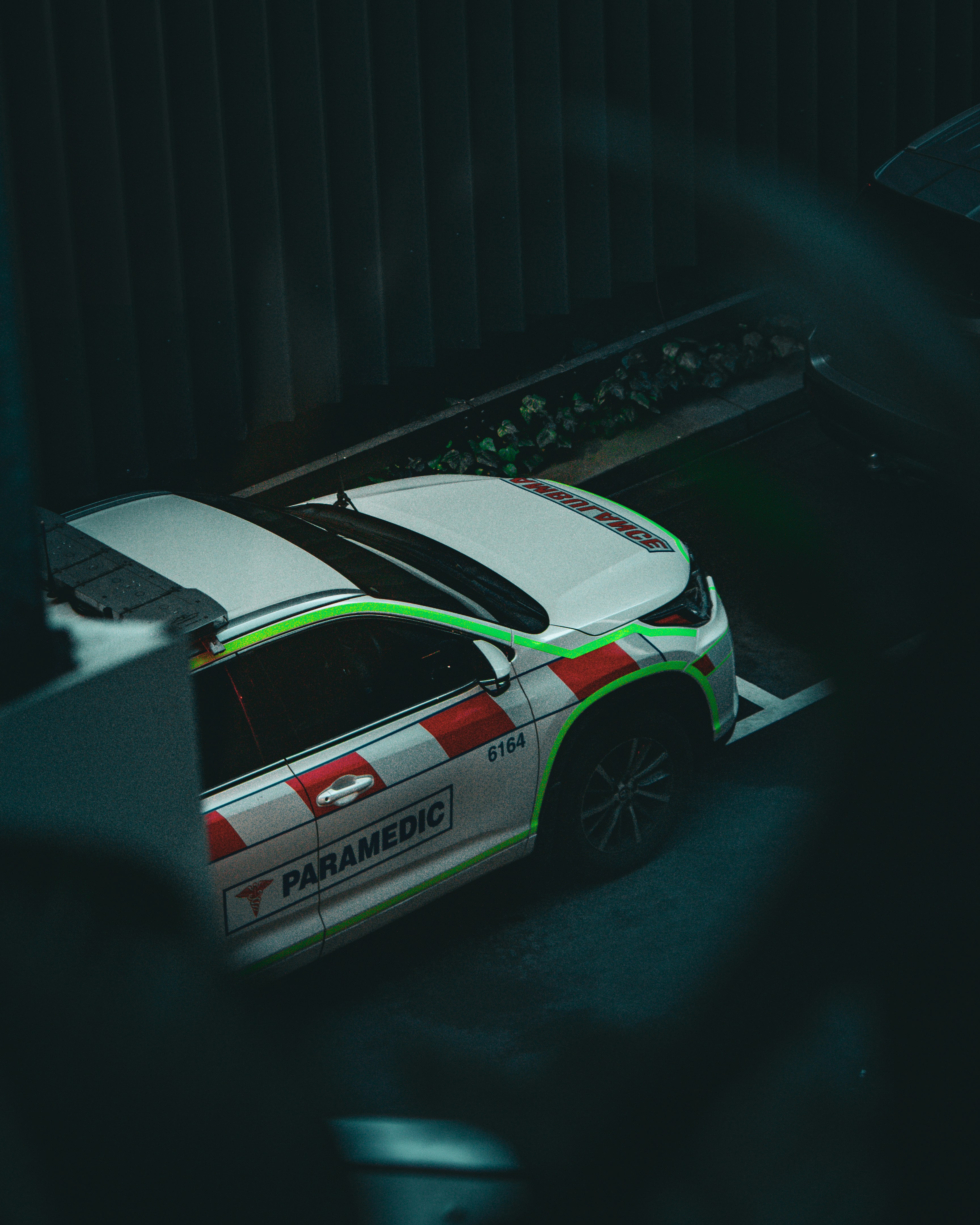 White paramedic vehicle with red and white markings.