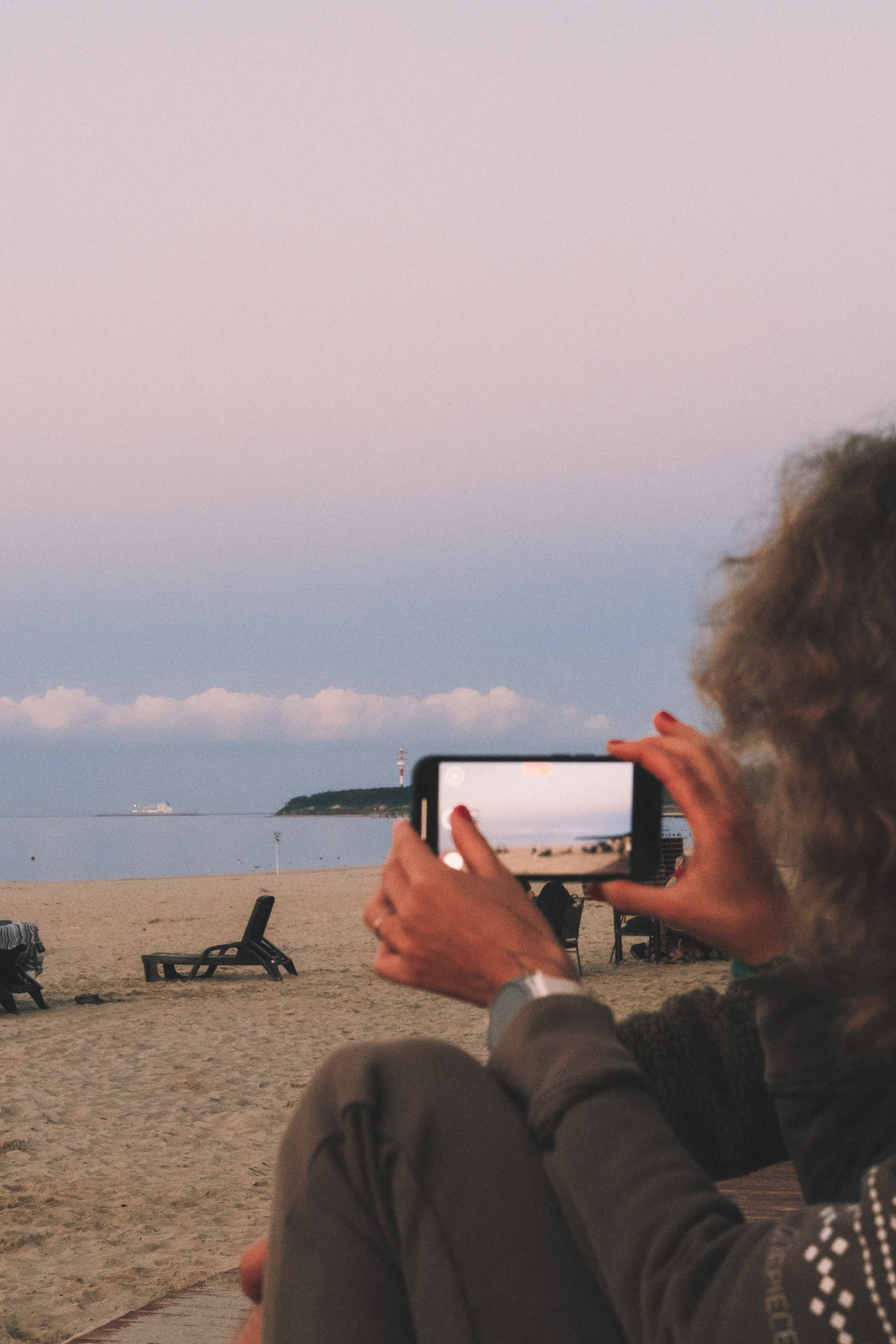 Créatrice de contenu filmant la plage avec téléphone — été 2026