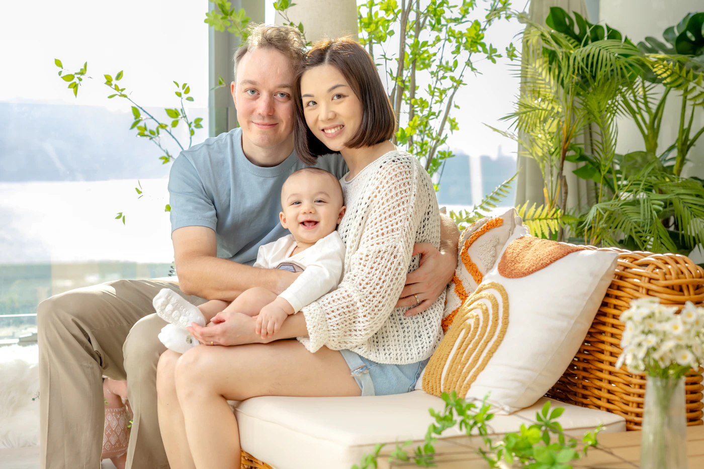 Parents smiling on the couch at home with their baby